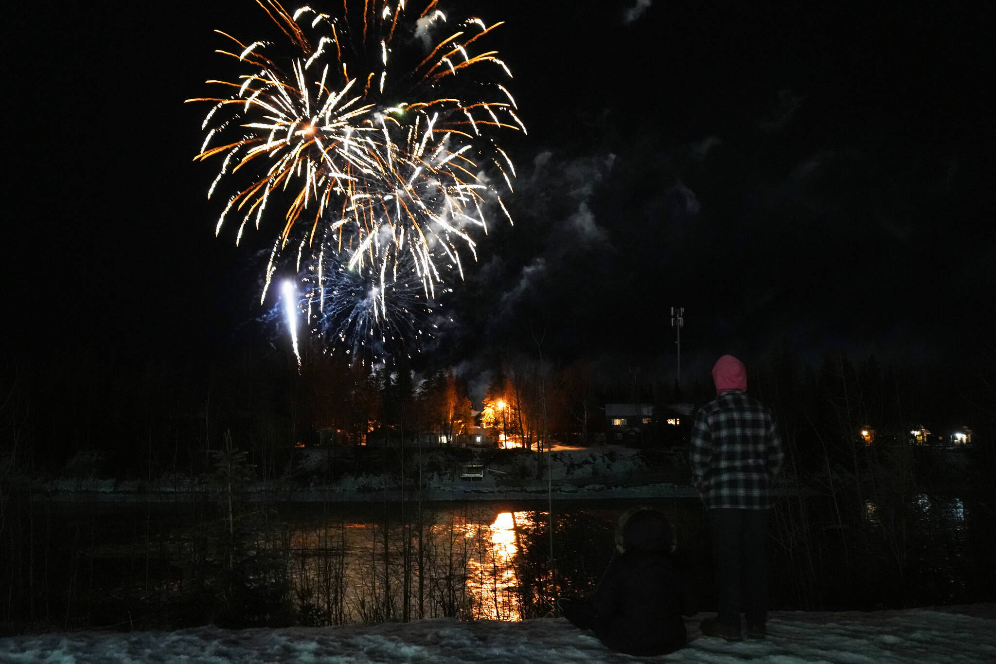 Lindsey, Cody and Lawson Farwell watch fireworks explode over the Kenai River during Christmas in the Park festivities at Soldotna Creek Park in Soldotna, Alaska, on Saturday, Dec. 2, 2023. (Jake Dye/Peninsula Clarion)
