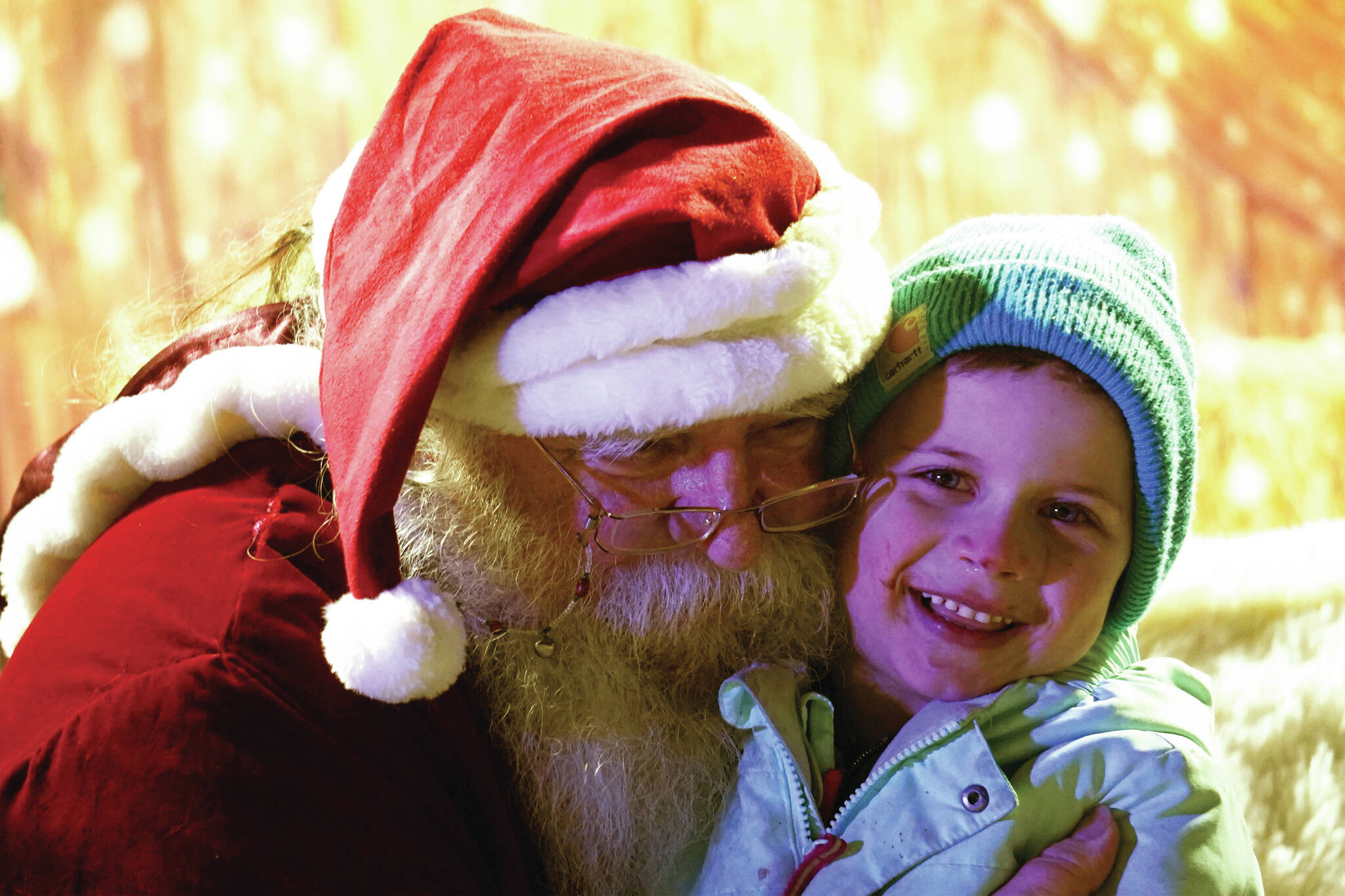 Jake Dye/Peninsula Clarion
Santa Claus hugs Paul Cook during Christmas in the Park festivities at Soldotna Creek Park on Saturday.