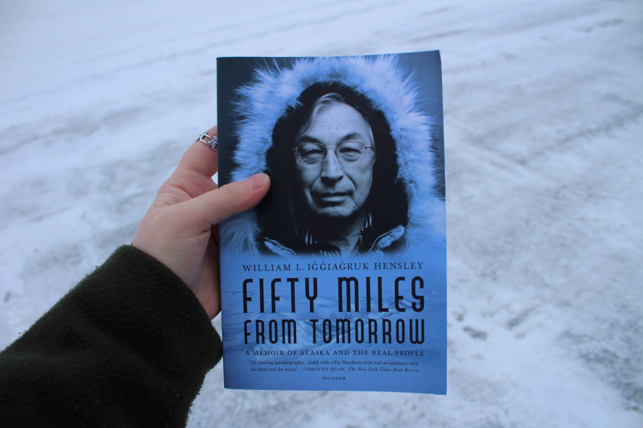 A copy of William L. Iġġiaġruk Hensley’s “Fifty Miles from Tomorrow” is held outside the Peninsula Clarion building on Tuesday, Dec. 12, 2023 in Kenai, Alaska. (Ashlyn O’Hara/Peninsula Clarion)