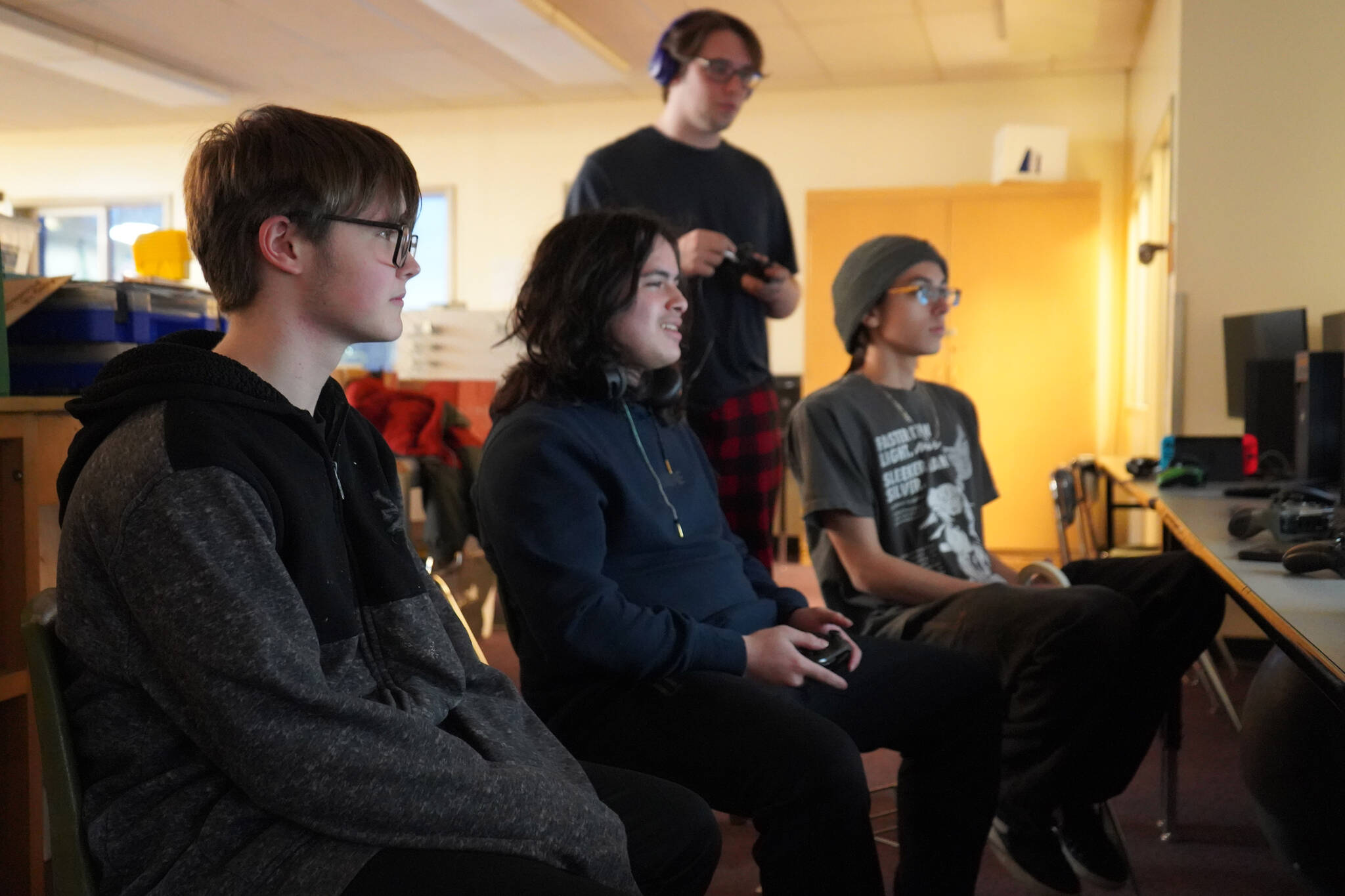 Eli Castro, center, competes while spectated by Blake Gillis, Kaizen Fuller and Kai Adkins during their state championship match against Lathrop High School in Super Smash Bros. Ultimate at Kenai Central High School in Kenai, Alaska, on Thursday, Dec. 14, 2023. (Jake Dye/Peninsula Clarion)