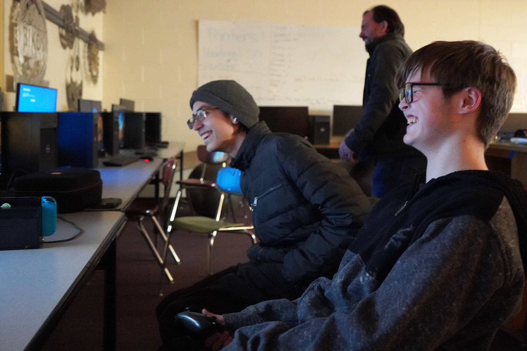 Blake Gillis, right, celebrates winning the final round and securing the state title alongside Kaizen Fuller and Coach Shane Lopez during their state championship match against Lathrop High School in Super Smash Bros. Ultimate at Kenai Central High School in Kenai, Alaska, on Thursday, Dec. 14, 2023. (Jake Dye/Peninsula Clarion)