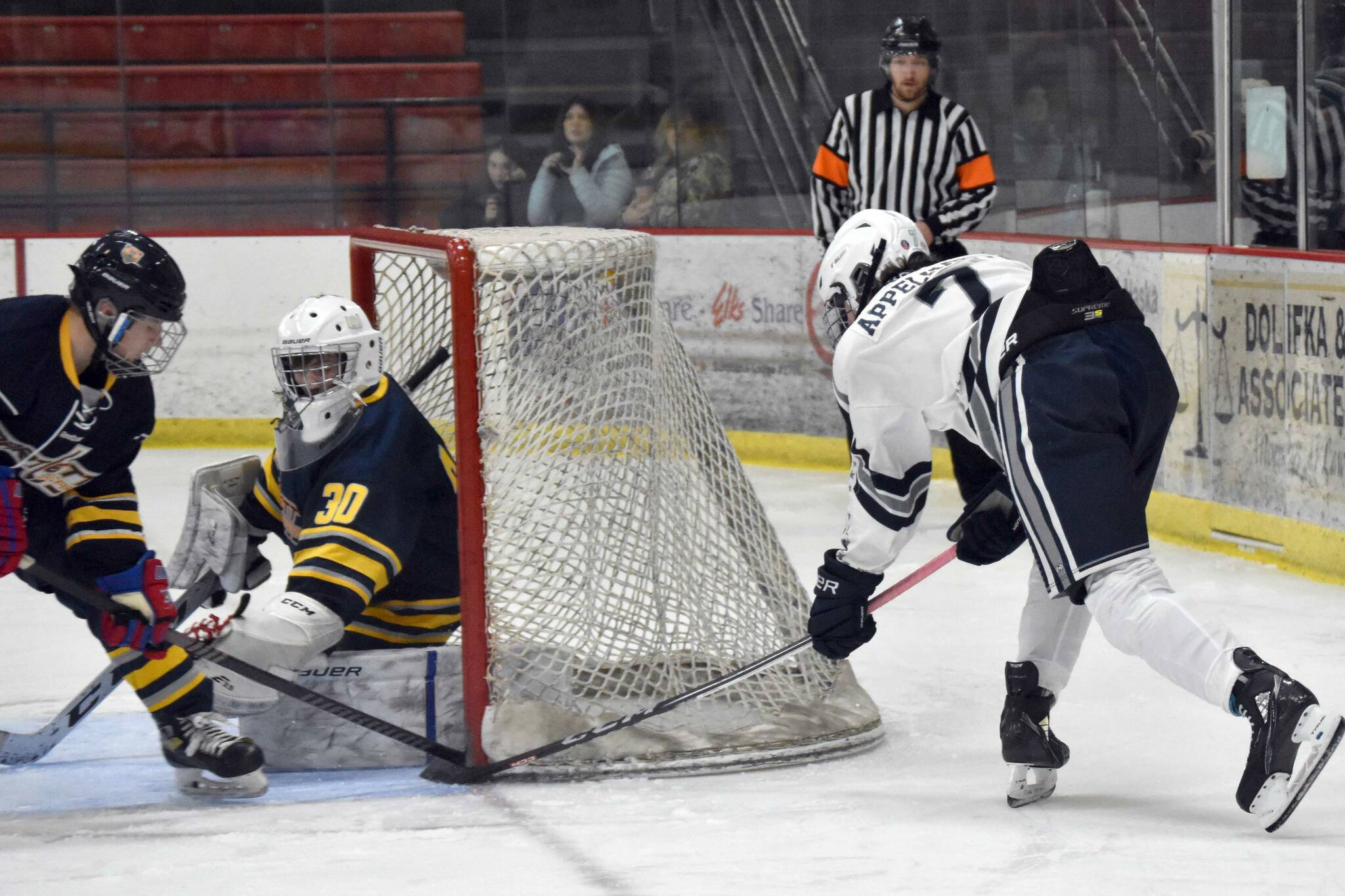 Soldotna's Jace Appelhans stuffs in a goal past Bartlett-East co-op goalie Reece Morton and defender Edwin Maxwell on Friday, Dec. 15, 2023, at the Soldotna Regional Sports Complex in Soldotna, Alaska. (Photo by Jeff Helminiak/Peninsula Clarion)