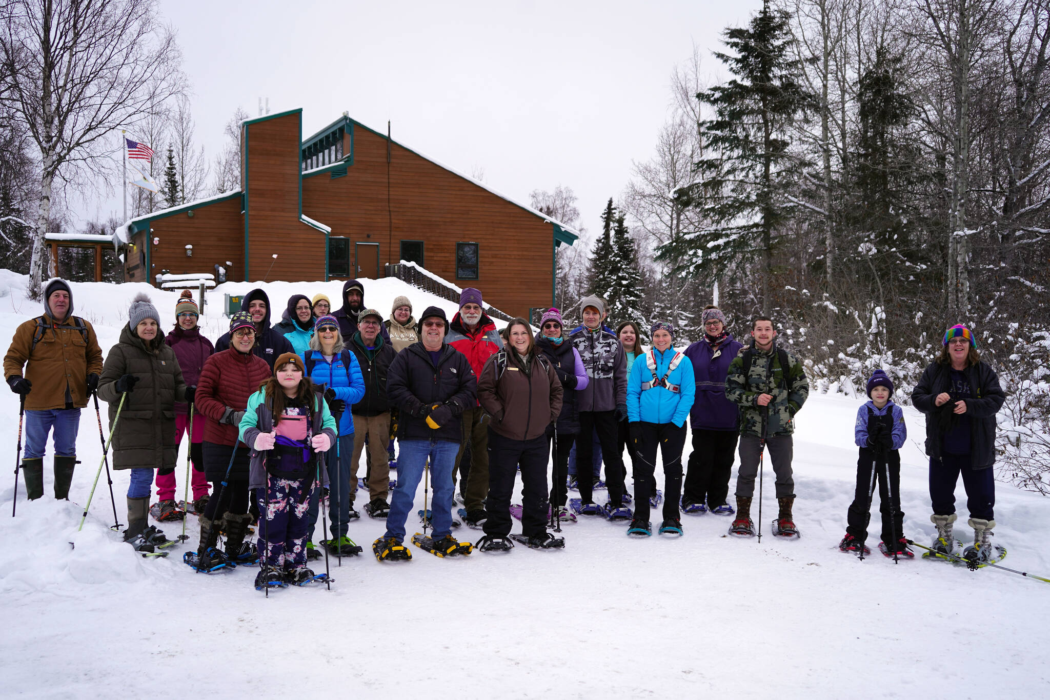 Around two dozen people gathered to snowshoe at the Kenai National Wildlife Refuge stand for a photo near Soldotna, Alaska, on Saturday, Jan. 6, 2024. (Jake Dye/Peninsula Clarion)