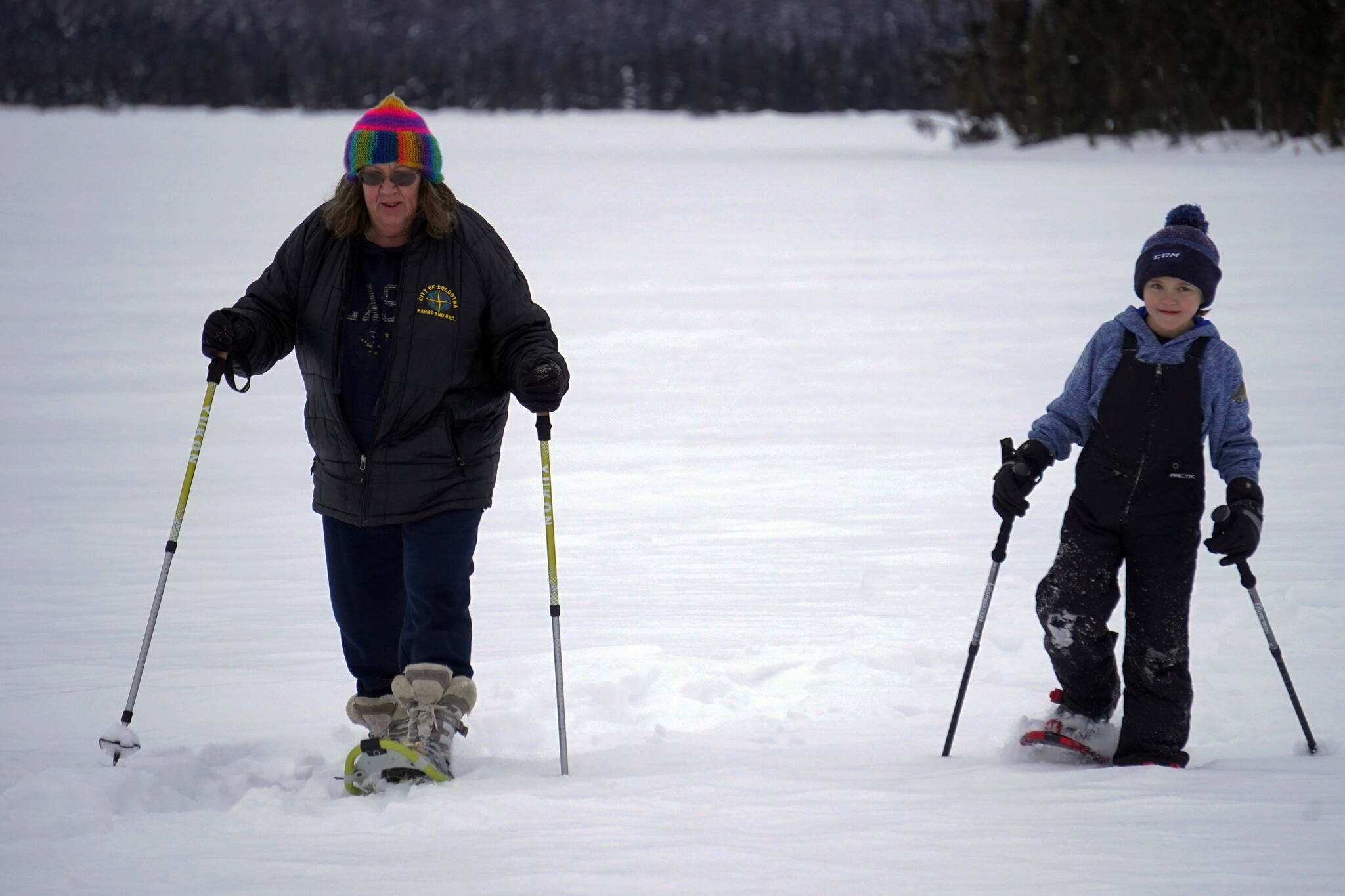 Dawn Lesterson and Kasyn Porterfield use snowshoes to cross Headquarters Lake in the Kenai National Wildlife Refuge near Soldotna, Alaska, on Saturday, Jan. 6, 2024. (Jake Dye/Peninsula Clarion)
