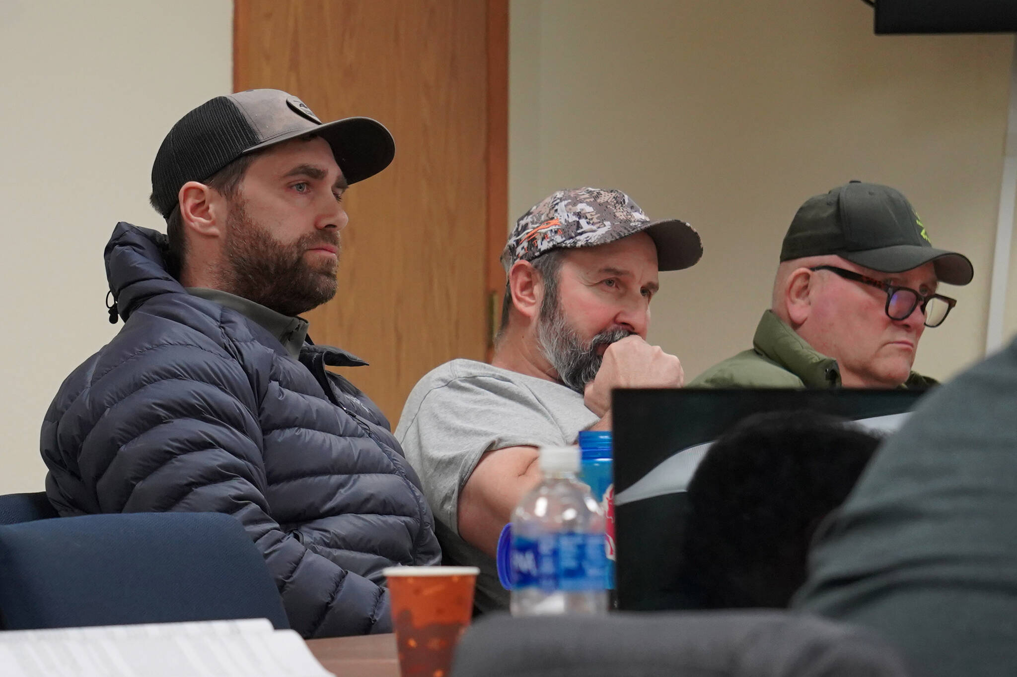 Scott Daletas, Monte Roberts and Jerry Strieby, all of whom sit in sport fishing guide seats, discuss proposals during a meeting of the Kenai/Soldotna Fish and Game Advisory Committee at Cook Inlet Aquaculture Association in Kenai, Alaska, on Monday, Jan. 8, 2024. (Jake Dye/Peninsula Clarion)