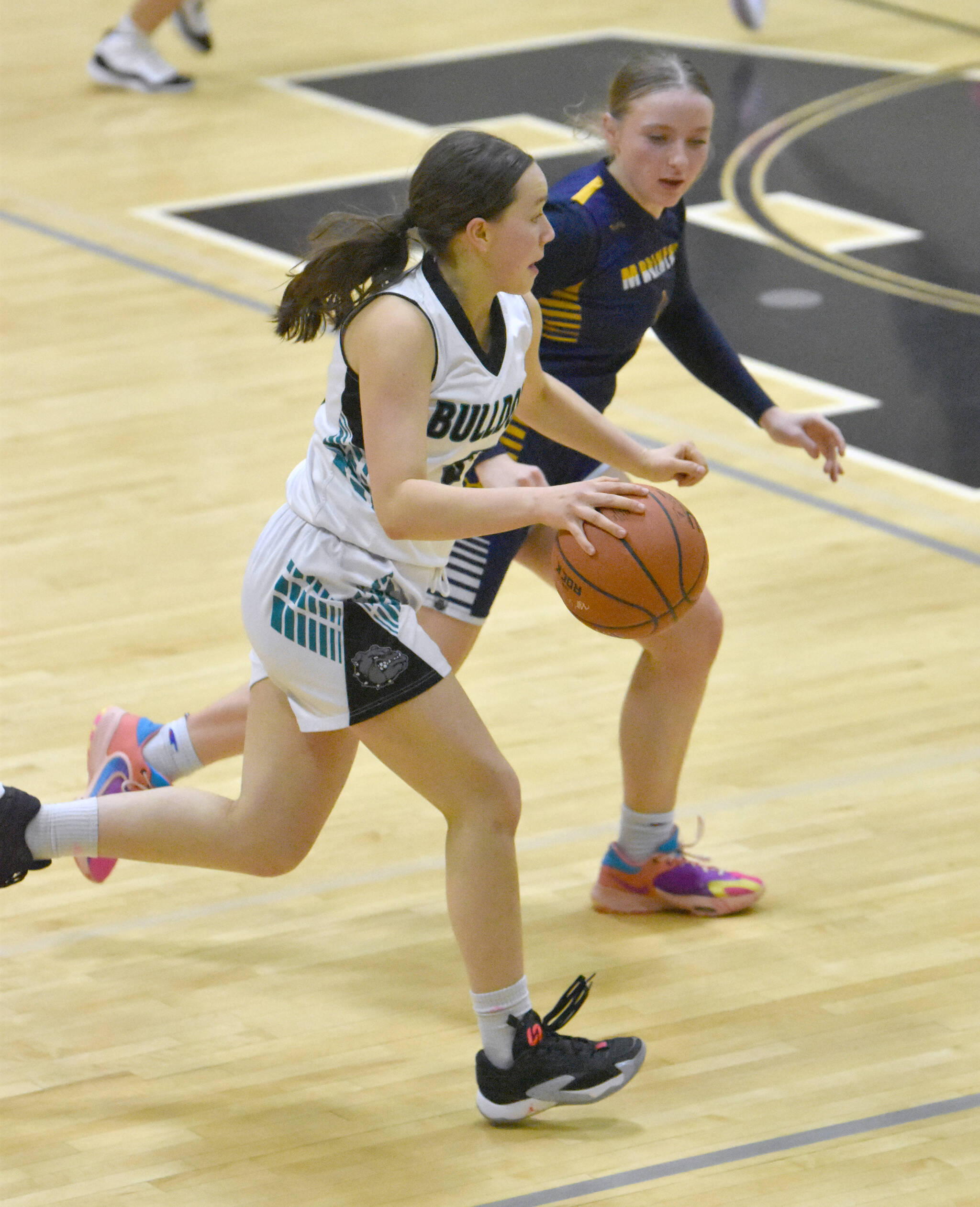 Nikiski’s Maggie Grenier dribbles against Homer’s Channing Lowney on Friday, Jan. 12, 2024, at Nikiski Middle-High School in Nikiski, Alaska. (Photo by Jeff Helminiak/Peninsula Clarion)