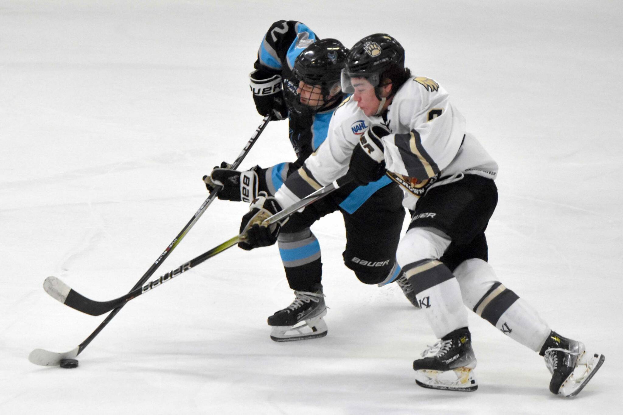 Erick Comstock of the Wisconsin Windigo and Dylan Contreras of the Kenai River Brown Bears battle for the puck Saturday, Jan. 20, 2024, at the Soldotna Regional Sports Complex in Soldotna, Alaska. (Photo by Jeff Helminiak/Peninsula Clarion)