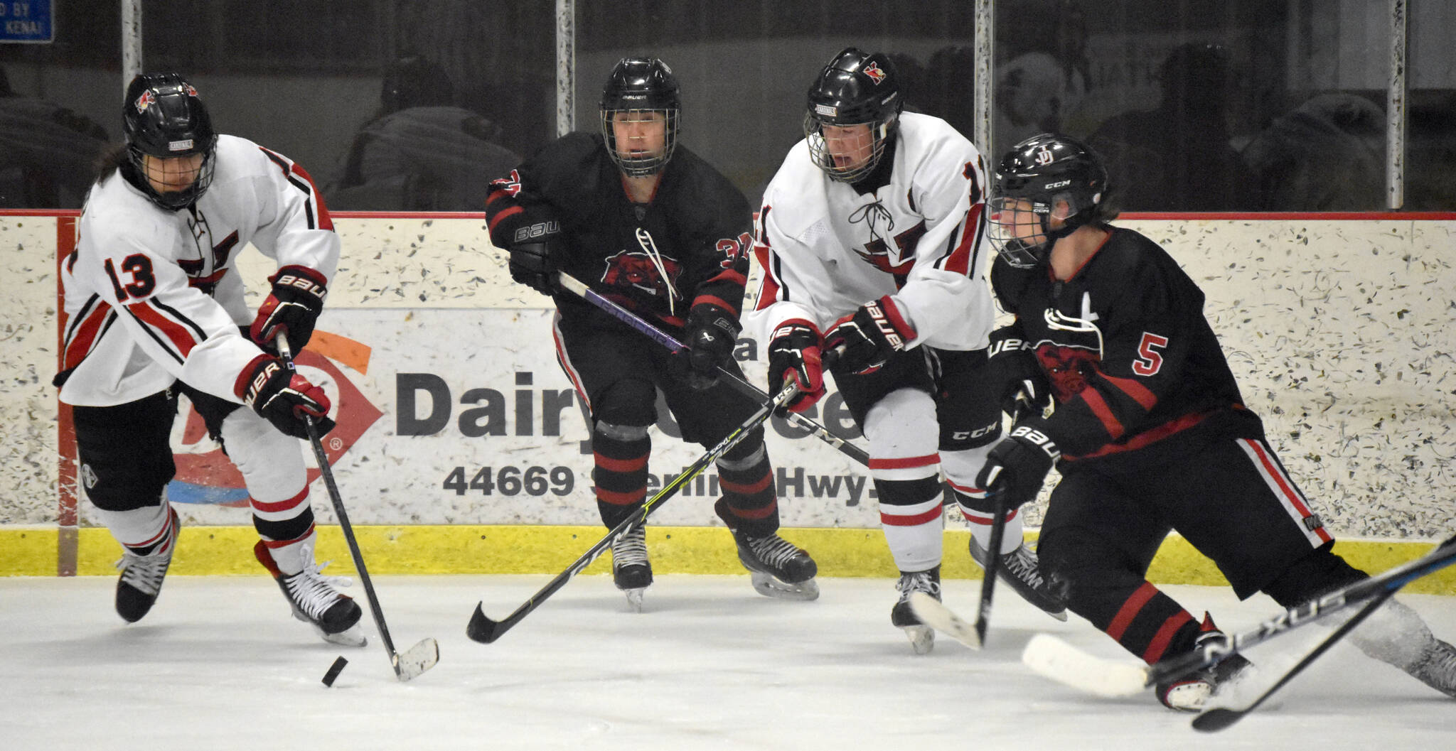 Kenai Centrals William Howard emerges from the crowd with the puck Friday, Jan. 19, 2024, at the Kenai Multi-Purpose Facility in Kenai, Alaska. (Photo by Jeff Helminiak/Peninsula Clarion)