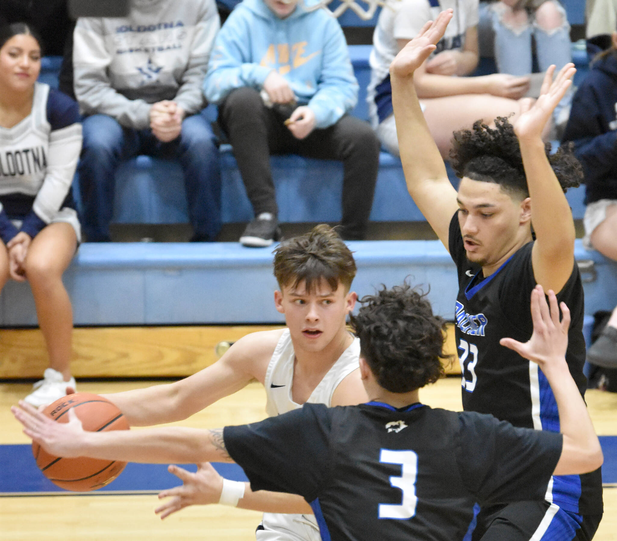 Soldotna’s Easton Hawkins drives on Palmer’s Logan McCann and Deandre Nika at the Revolution Sport and Spine Therapy Al Howard Shootout on Thursday, Jan. 25, 2024, at Soldotna High School in Soldotna, Alaska. (Photo by Jeff Helminiak/Peninsula Clarion)