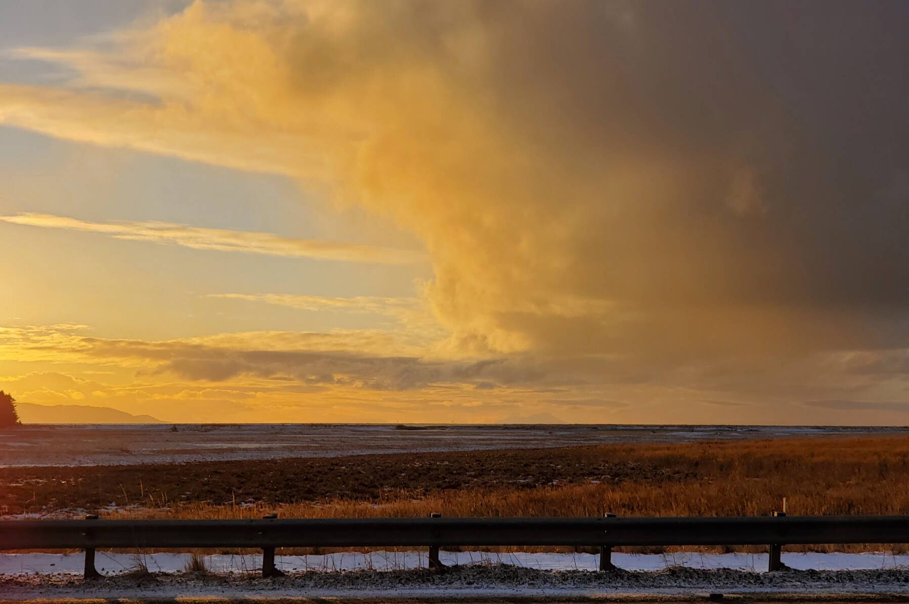 The setting sun casts the sky in gold over Kachemak Bay on Friday, Dec. 8, 2023 in Homer, Alaska. (Delcenia Cosman/Homer News)