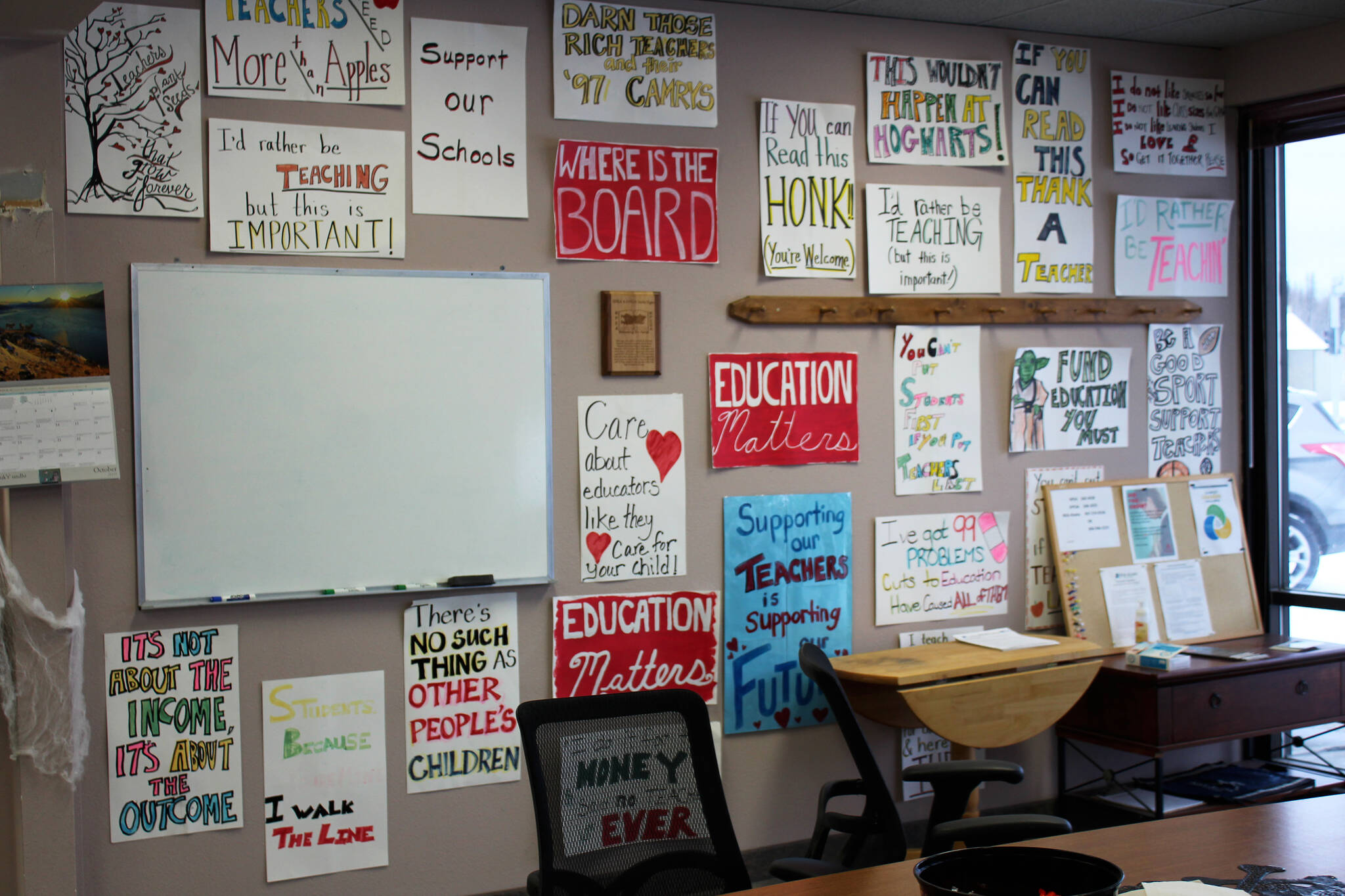 Protest signs hang on the entryway wall at the Kenai Peninsula Education Association office on Thursday, Oct. 28, 2021, in Soldotna, Alaska. (Ashlyn O’Hara/Peninsula Clarion)