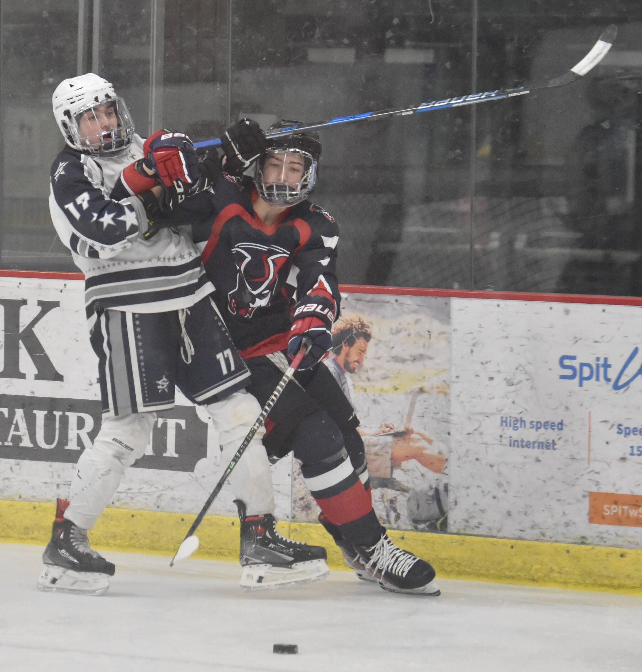 Soldotna’s Mykah Booth and North Pole’s Kagen Kramer battle for the puck Thursday, Feb. 1, 2024, at the Division II state hockey tournament at the Soldotna Regional Sports Complex in Soldotna, Alaska. (Photo by Jeff Helminiak/Peninsula Clarion)
