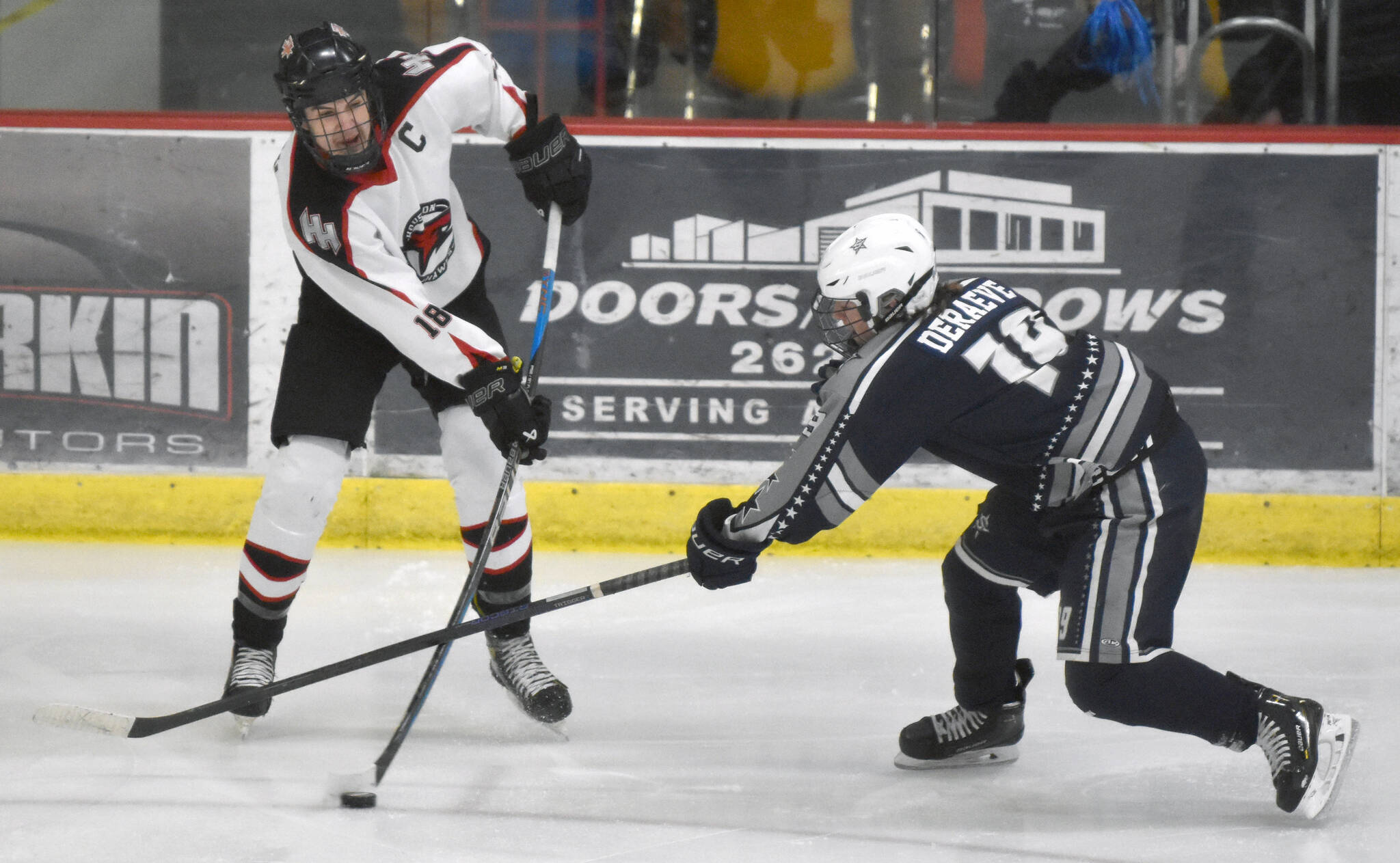 Soldotna’s Marshall DeRaeve tries to keep Houston’s Afanasy Efimov from clearing the puck at the Division II state hockey tournament Saturday, Feb. 3, 2024, at the Soldotna Regional Sports Complex in Soldotna, Alaska. (Photo by Jeff Helminiak/Peninsula Clarion)