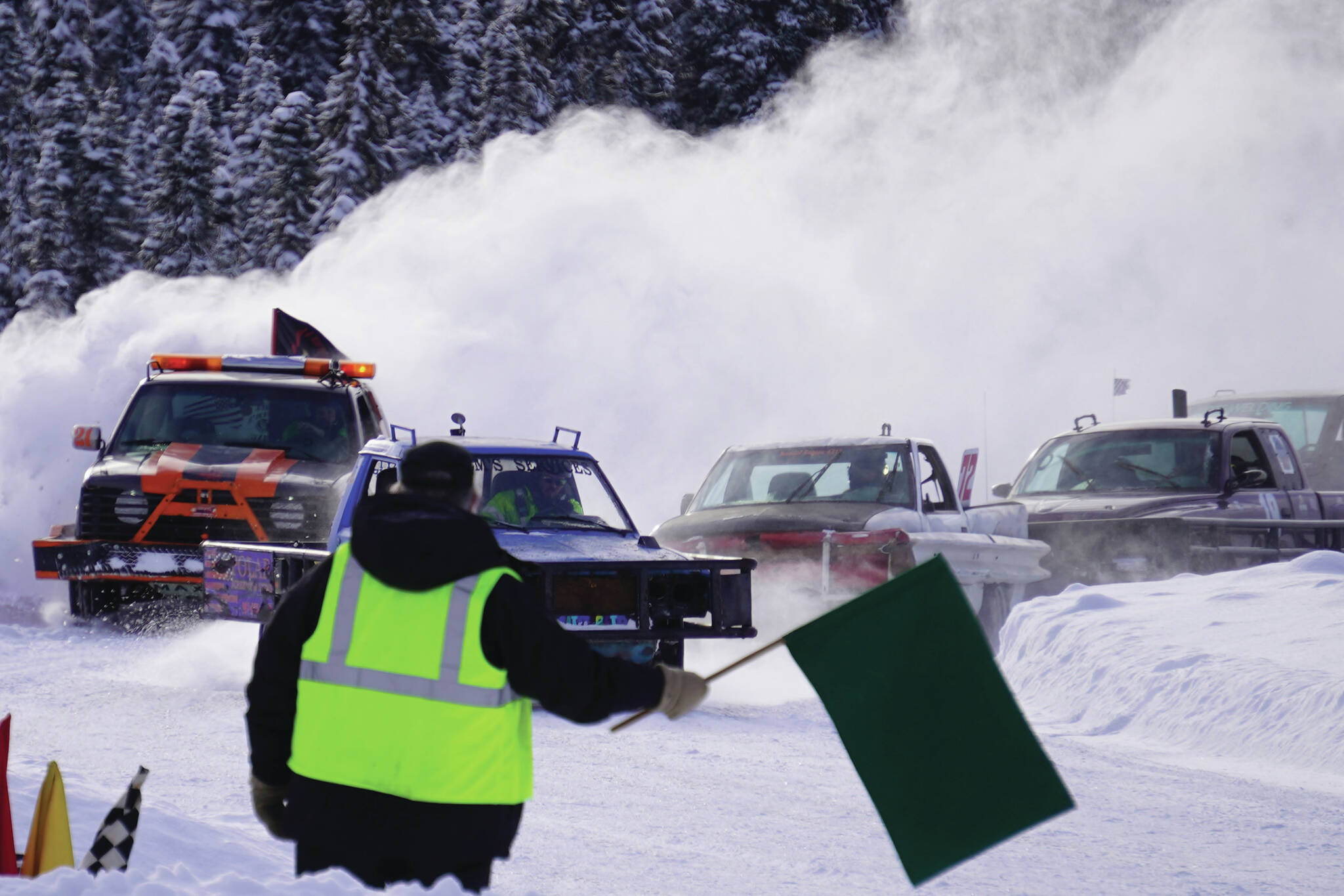 A tight pack of vehicles round the bend to complete a lap during Kenai Peninsula Ice Racing at the Decanter Inn in Kasilof on Sunday. (Jake Dye/Peninsula Clarion)