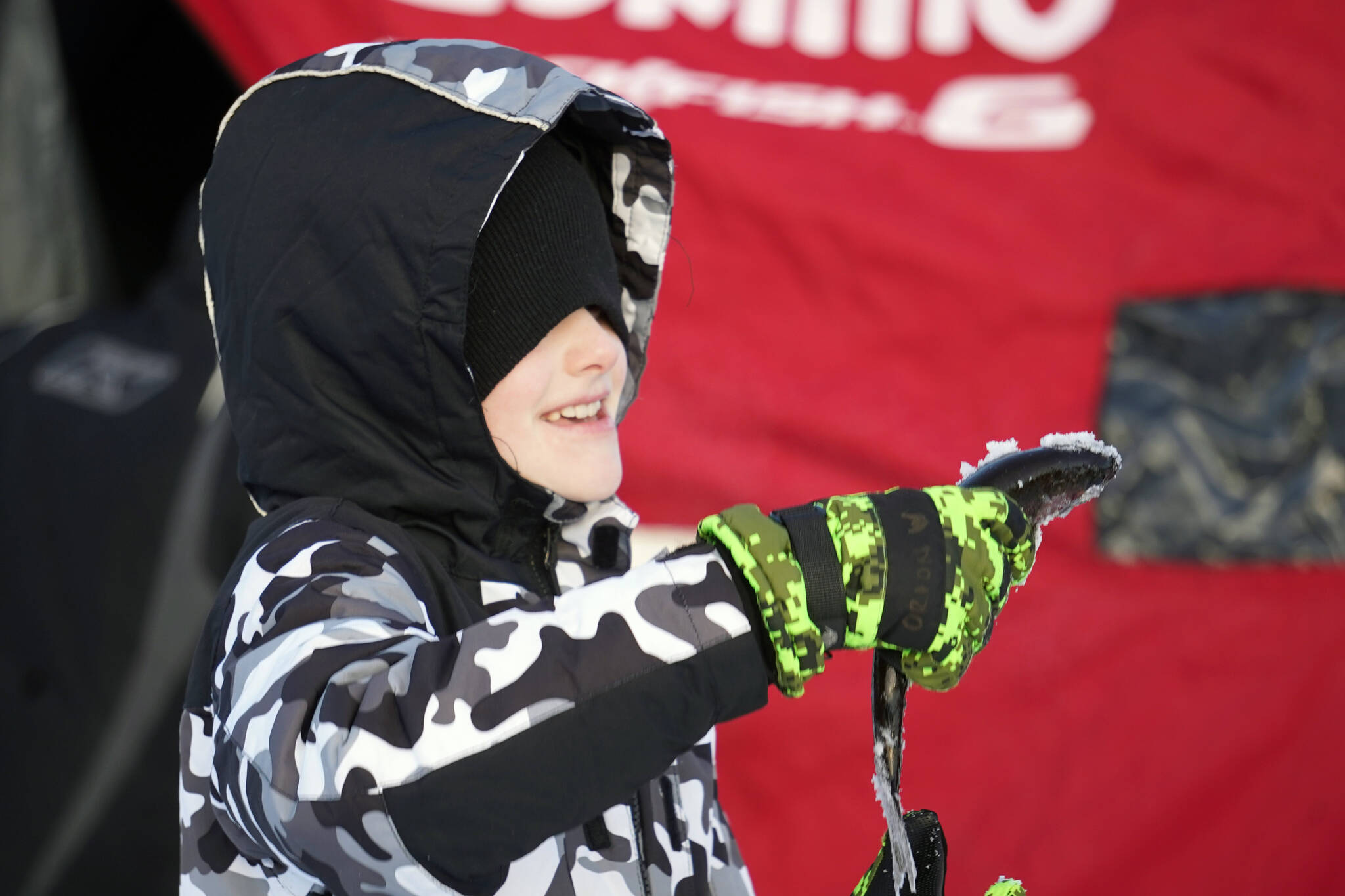 Orion Willis, a student of Soldotna Montessori, holds up a rainbow trout he caught during Salmon in the Classroom ice fishing at Sport Lake in Soldotna, Alaska, on Tuesday, Feb. 6, 2024. (Jake Dye/Peninsula Clarion)