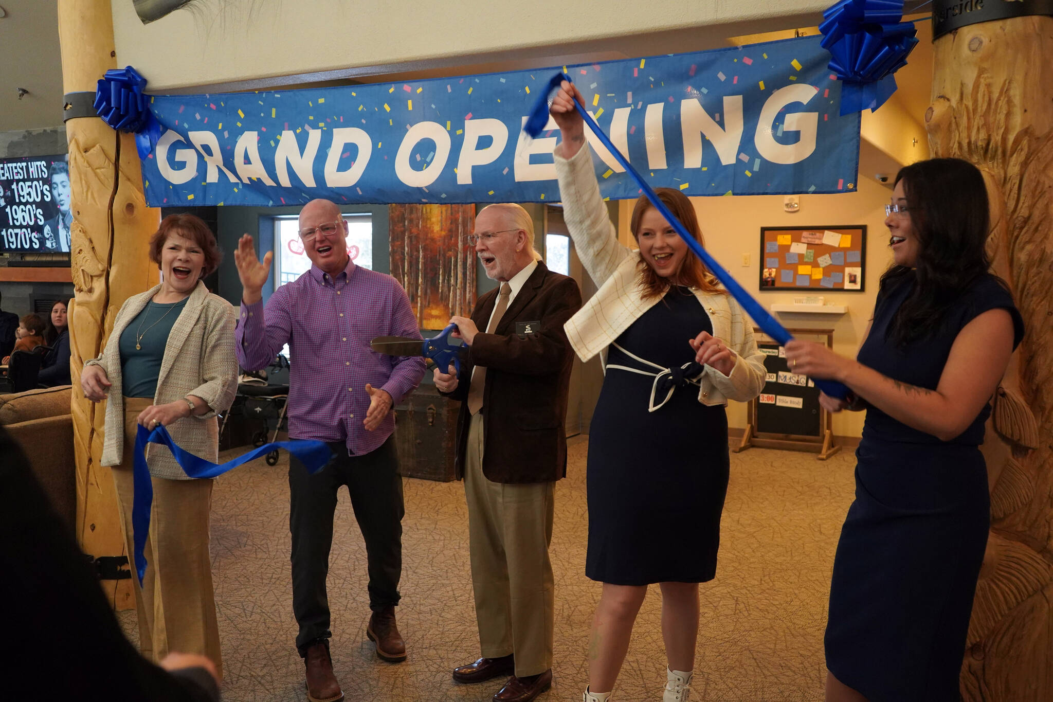 Soldotna Mayor Paul Whitney, center, and representatives of Aspen Creek Senior Living celebrate a ribbon cutting during a grand opening event at Aspen Creek Senior Living in Soldotna, Alaska, on Friday, Feb. 9, 2024. (Jake Dye/Peninsula Clarion)