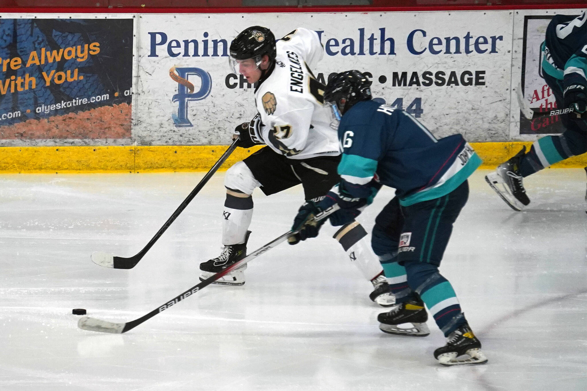 Kenai River’s Brady Engelkes and Anchorage’s Will Shepard battle for control of the puck during a hockey game at the Soldotna Regional Sports Complex in Soldotna, Alaska, on Friday, Feb. 16, 2024. (Jake Dye/Peninsula Clarion)