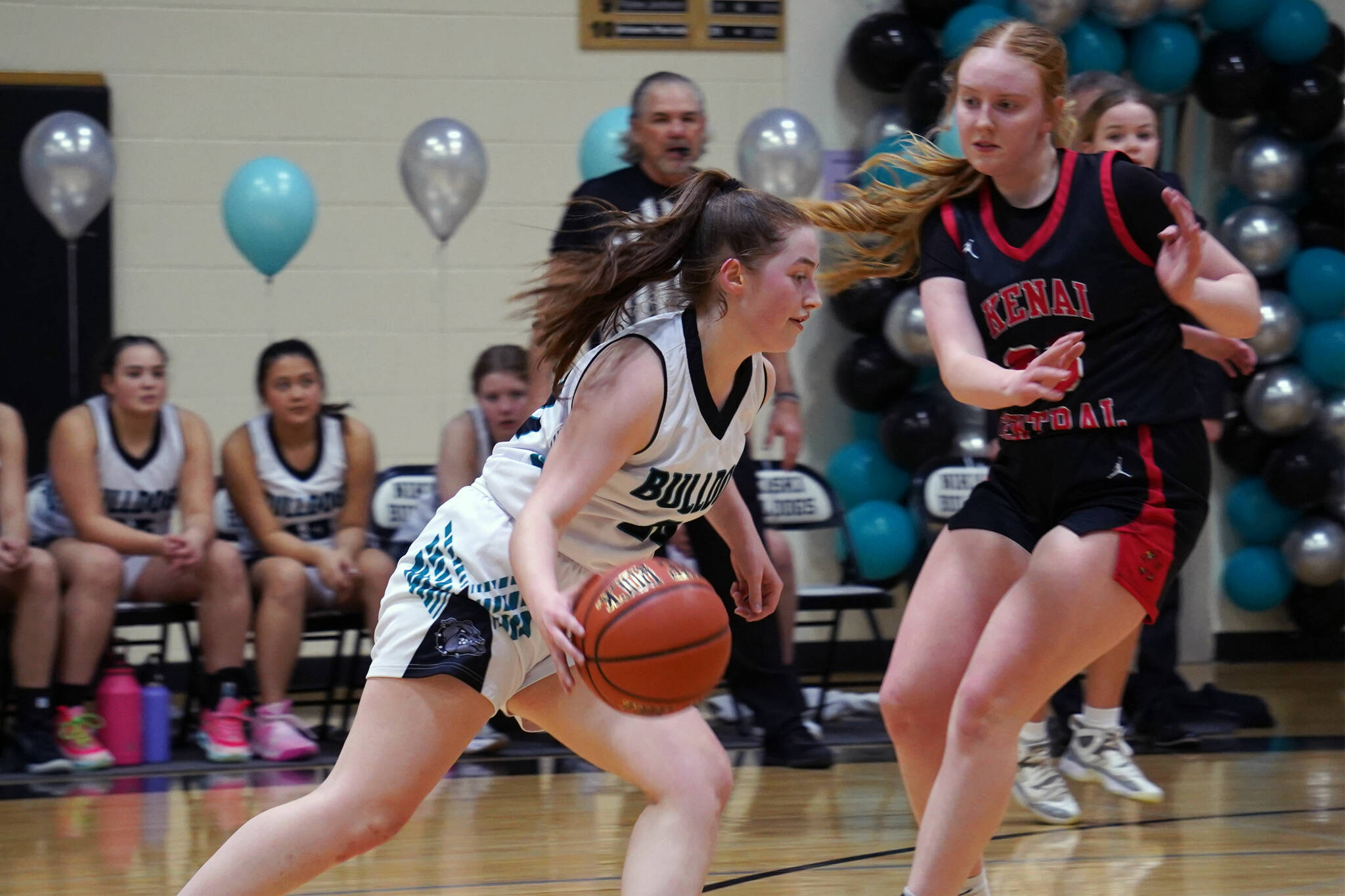 Nikiski’s Avery Ellis moves with the ball against blocking by Kenai’s Ellsi Miller during a basketball game at Nikiski Middle/High School in Nikiski, Alaska, on Tuesday, Feb. 20, 2024. (Jake Dye/Peninsula Clarion)