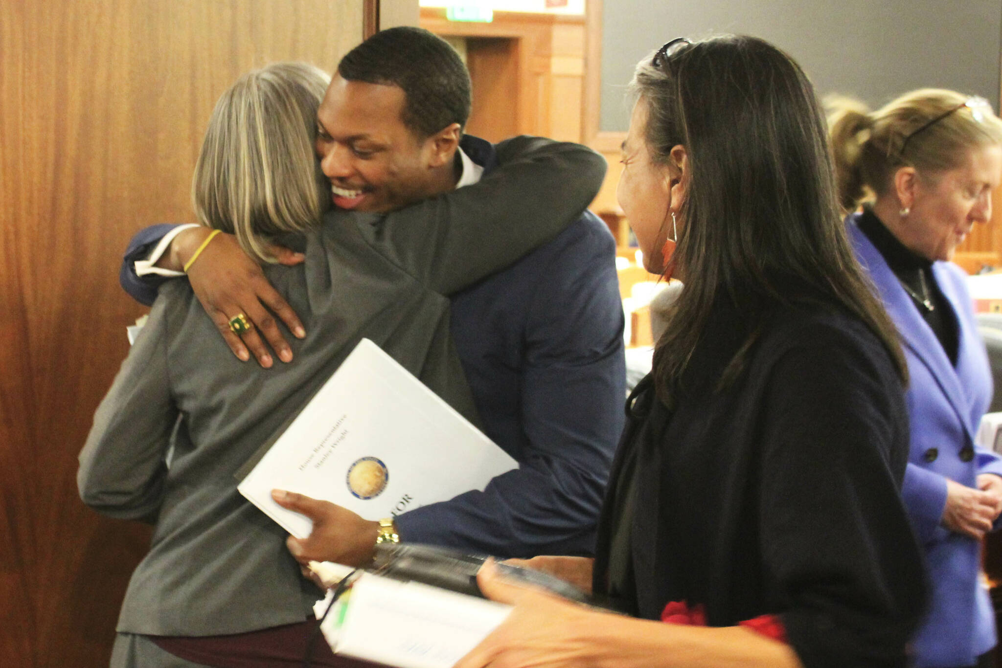 From left, Rep. Andi Story, D-Juneau, hugs Rep. Stanley Wright, R-Anchorage, after House passage of sweeping education legislation while Rep. Maxine Dibert, D-Fairbanks, watches on Thursday, Feb. 22, 2024, in Juneau, Alaska. (Ashlyn O’Hara/Peninsula Clarion)