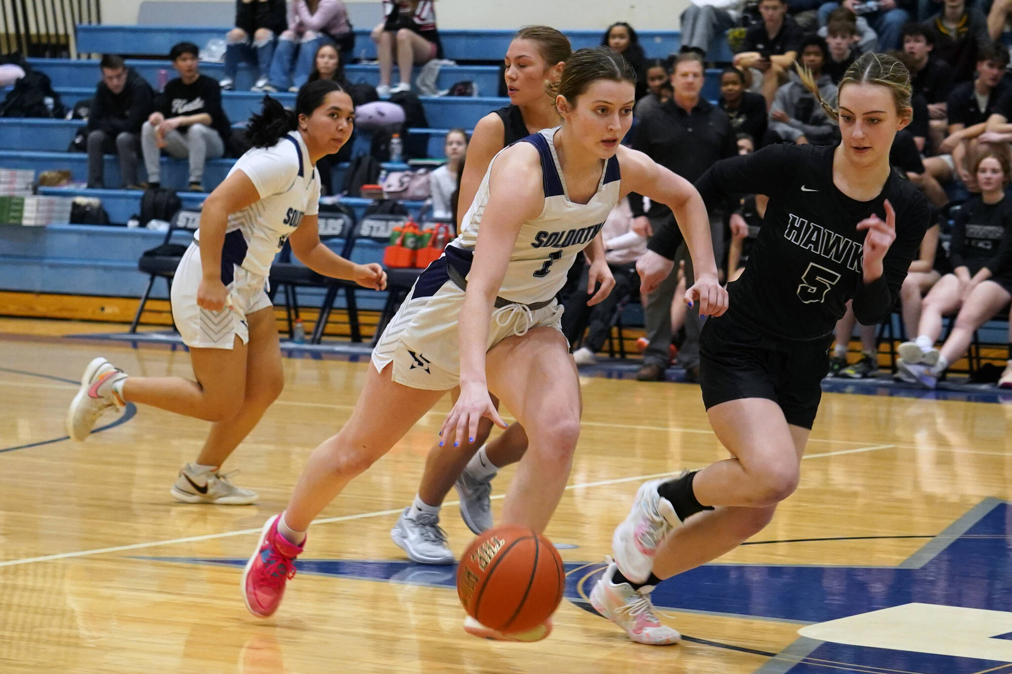 Soldotna’s Kaytlin McAnelly, backed by teammate Izzy Cruz, moves with the ball against defensive play by Houston’s Andi Robinson during a basketball game at Soldotna High School in Soldotna, Alaska, on Friday, Feb. 23, 2024. (Jake Dye/Peninsula Clarion)