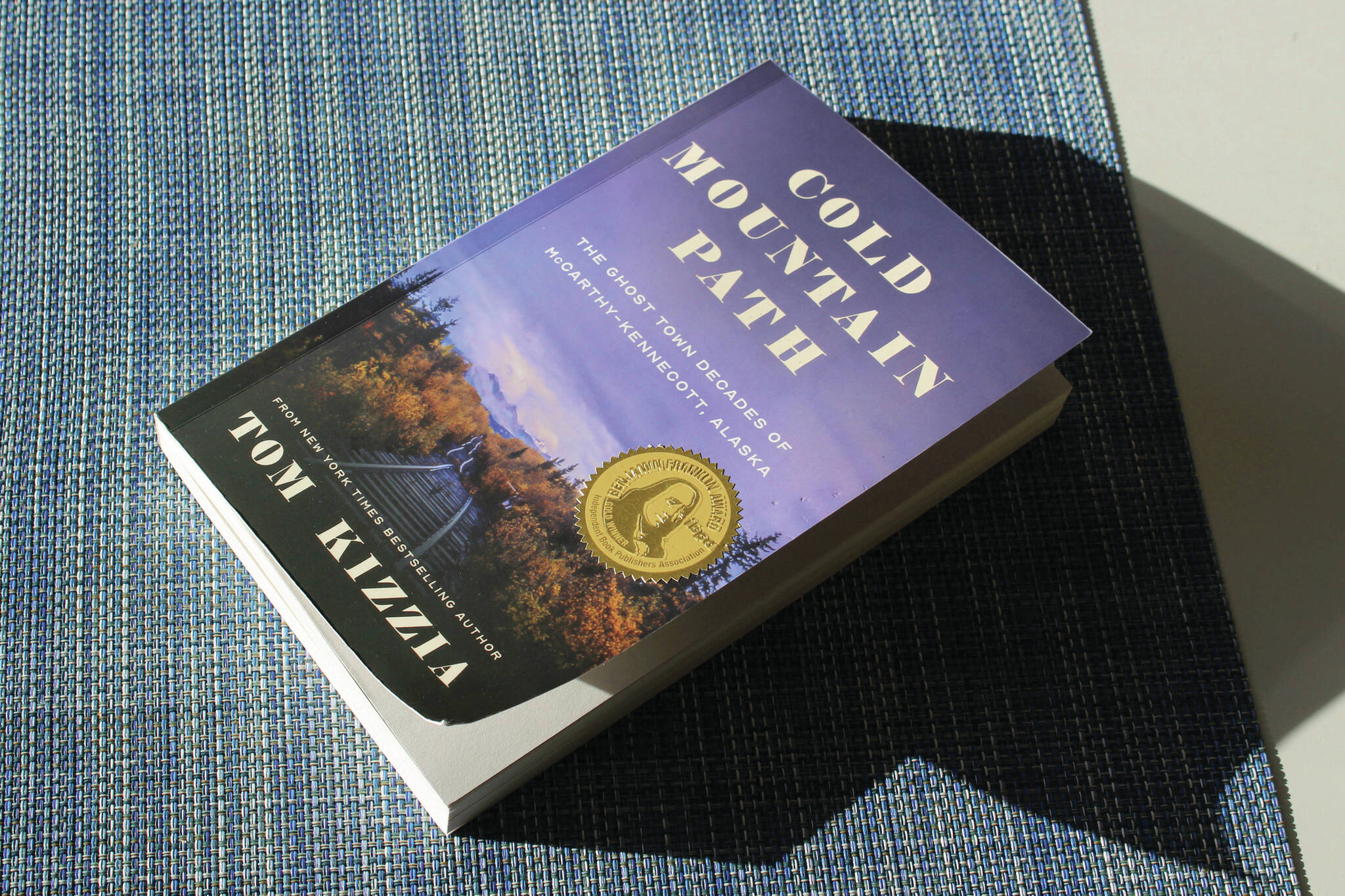A copy of Tom Kizzia’s “Cold Mountain Path” rests on a table on Thursday in Juneau. (Ashlyn O’Hara/Peninsula Clarion)