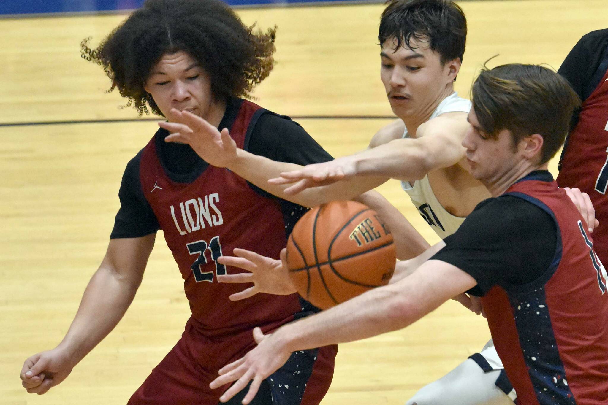 Serge Duchatellier and Lukas Underhile of Mountain City Christian Academy and Cameron LaRoque of Soldotna battle for the ball Thursday, March 7, 2024, at the Northern Lights Conference tournament at Soldotna High School in Soldotna, Alaska. (Photo by Jeff Helminiak/Peninsula Clarion)