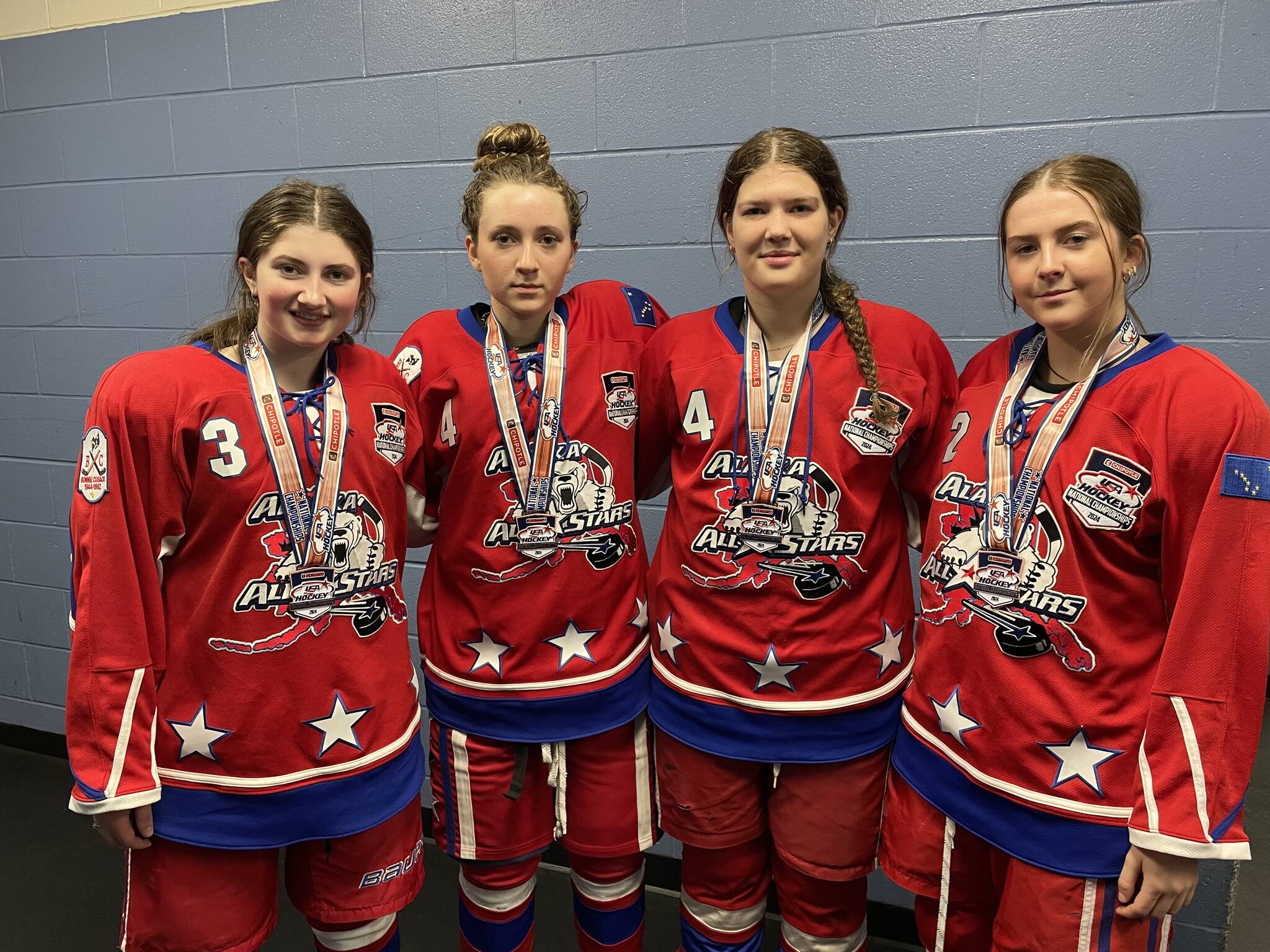 Lily Langham of Kenai Central High School and Brooklyn Larsen, Rylie Thompson and Ava Fabian of Soldotna High School, stand for a photo with their medals after competing in the USA Hockey National Championships as part of the Alaska All Stars 19U Division 2A hockey team. (Photo provided)