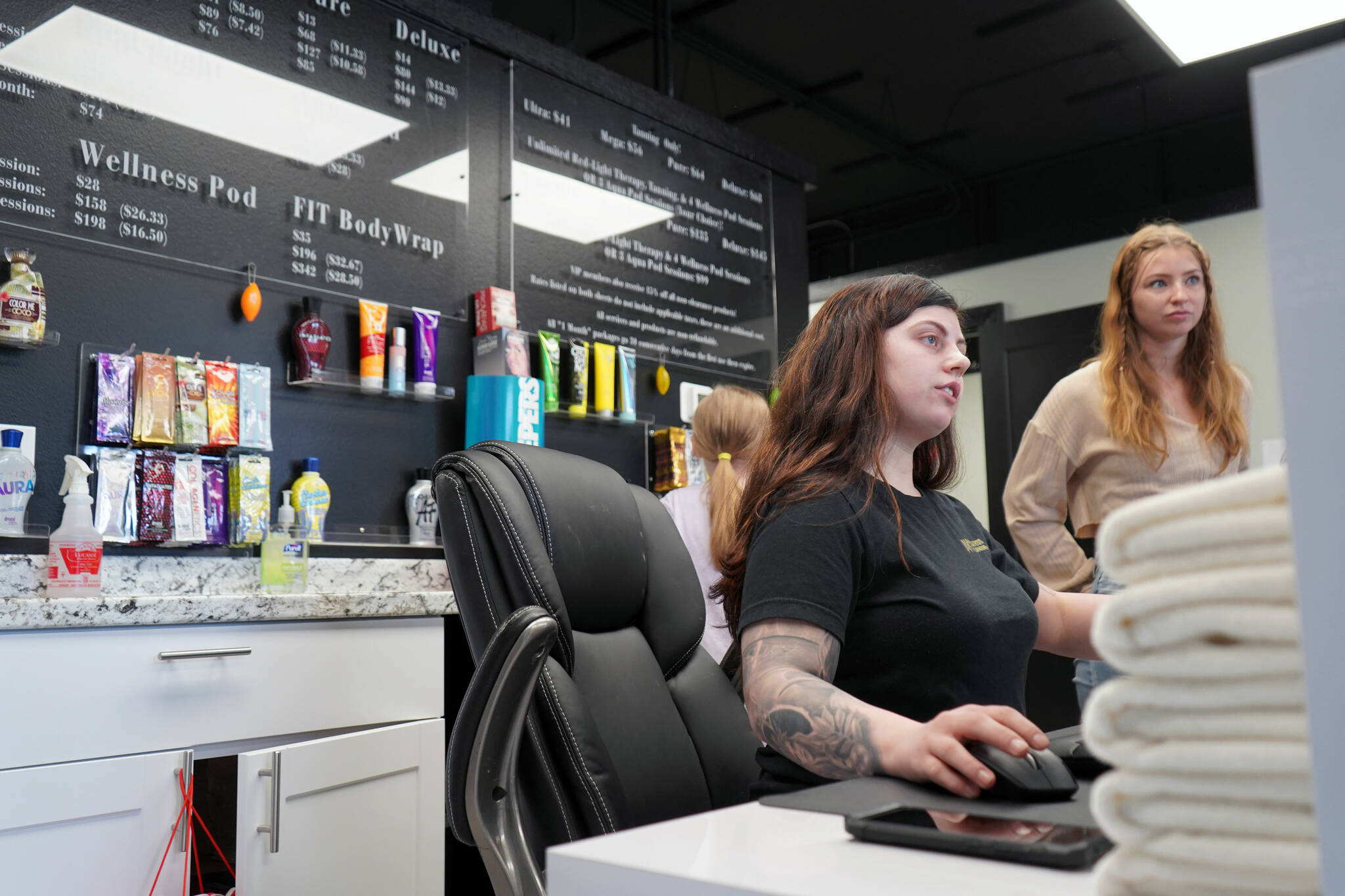 Vanessa Uei checks in guests during a grand opening for AK Wellness & Tanning in Kenai, Alaska, on Saturday, April 6, 2024. (Jake Dye/Peninsula Clarion)