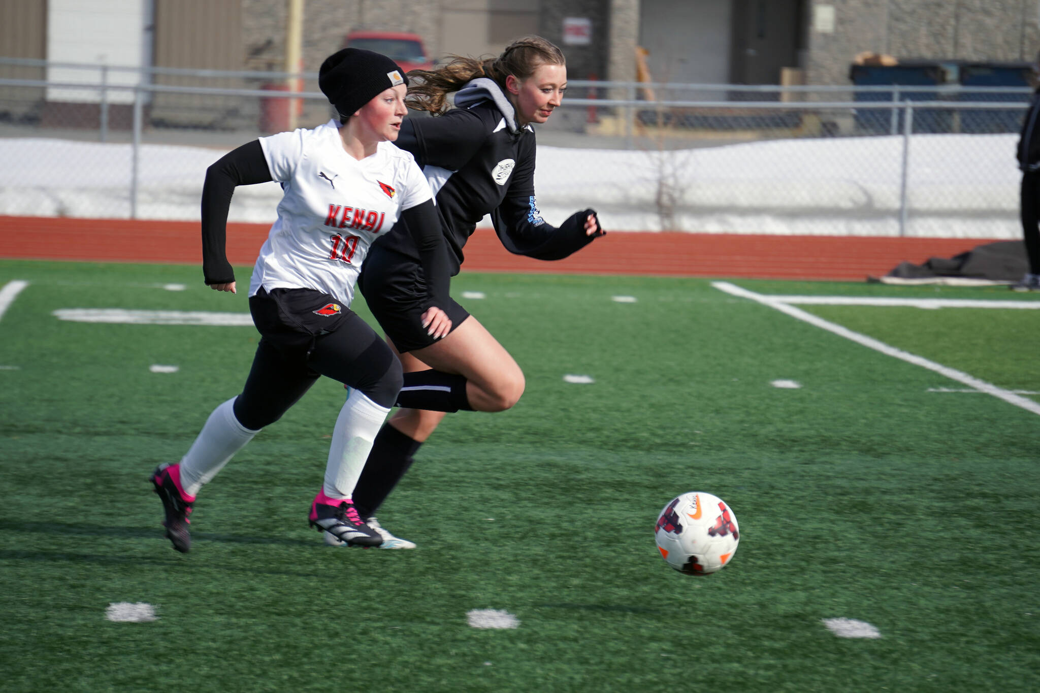Kenai Central’s Kylee Verkuilen races Nikiski for control of the ball during a soccer game at Ed Hollier Field in Kenai, Alaska, on Friday, April 12, 2024. (Jake Dye/Peninsula Clarion)
