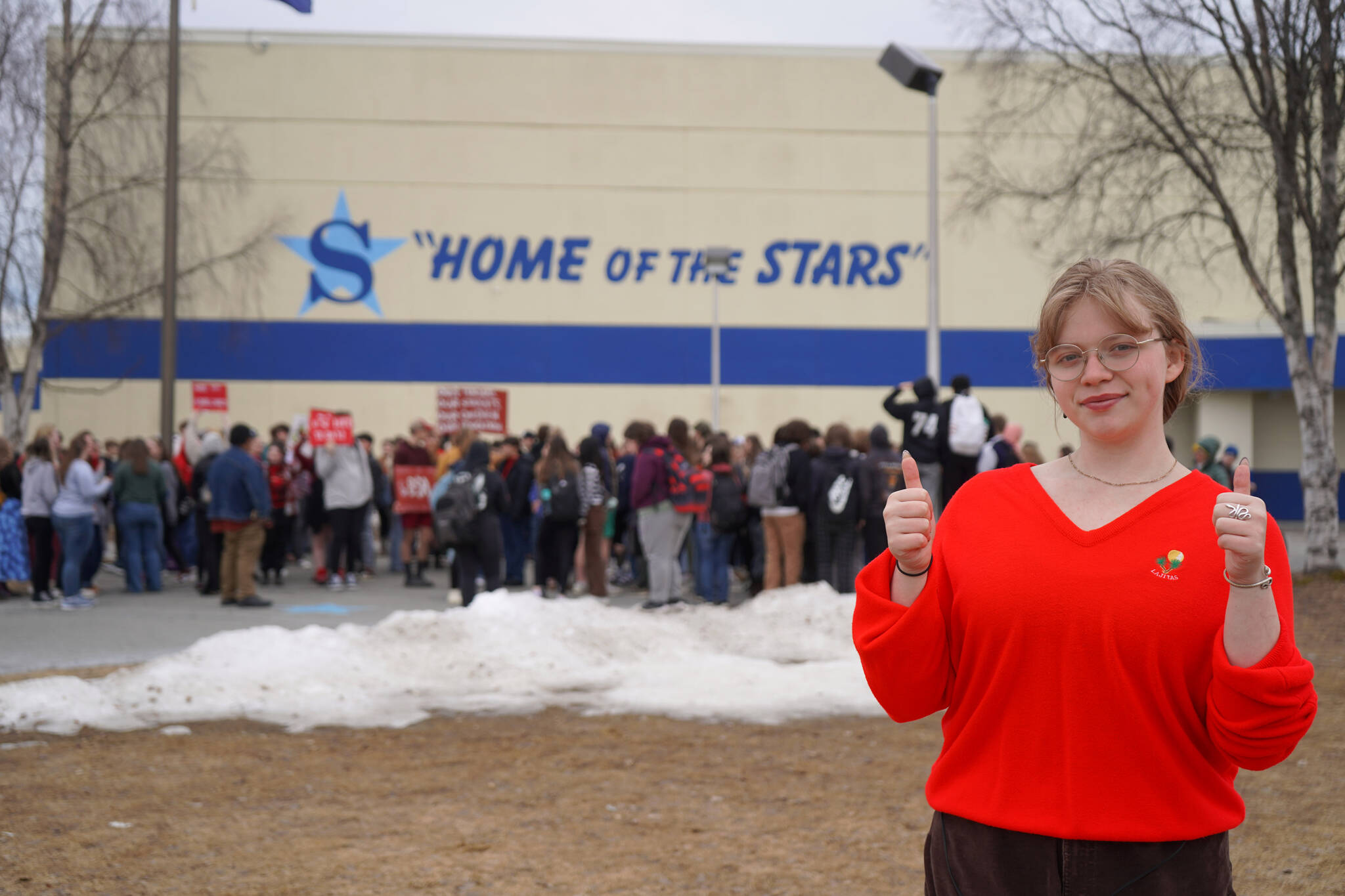 JLee Webster stands in front of roughly 150 Soldotna High School students who participated in a walk out in protest of the veto of Senate Bill 140 in front of their school in Soldotna, Alaska, on Wednesday, April 17, 2024. (Jake Dye/Peninsula Clarion)