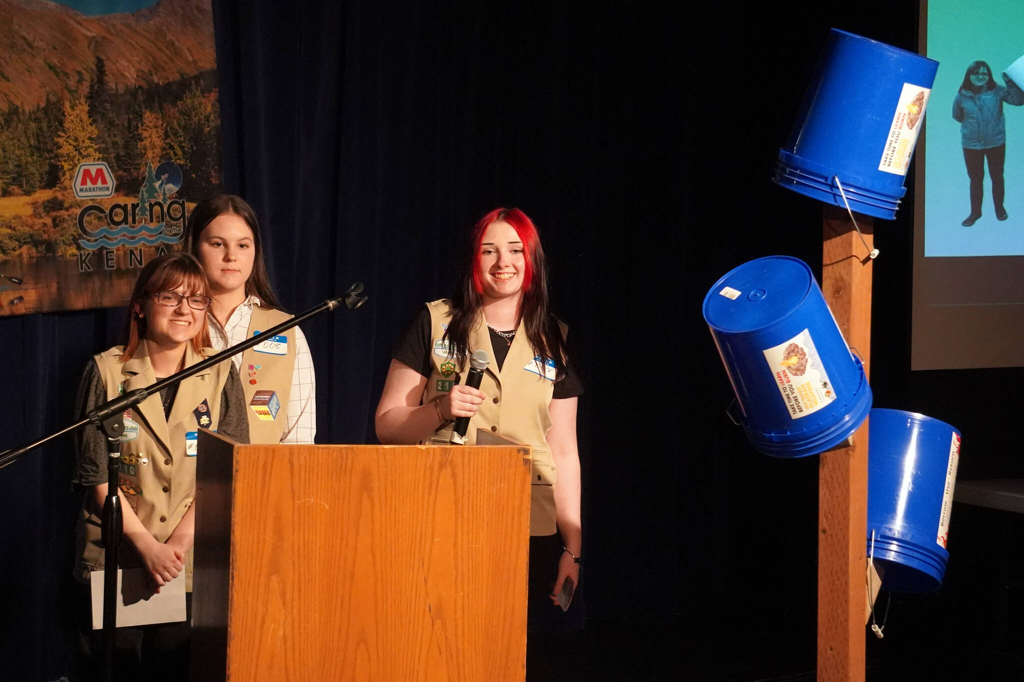 Girl Scout Troop 210, which includes Caitlyn Eskelin, Emma Hindman, Kadie Newkirk and Lyberty Stockman, present their “Bucket Trees” to a panel of judges in the 34th Annual Caring for the Kenai Competition at Kenai Central High School in Kenai, Alaska, on Thursday, April 18, 2024. (Jake Dye/Peninsula Clarion)