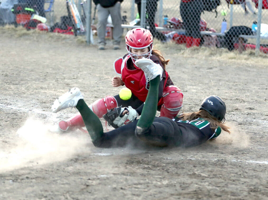 (Bruce Eggleston/matsusports.net) Colony’s Kara Macy slides into home safely as the ball bounces in front of Kenai Central catcher Maggie Grenier at the Rally in the Valley tournament Thursday, April 25, 2024, at Colony Middle School in Palmer.