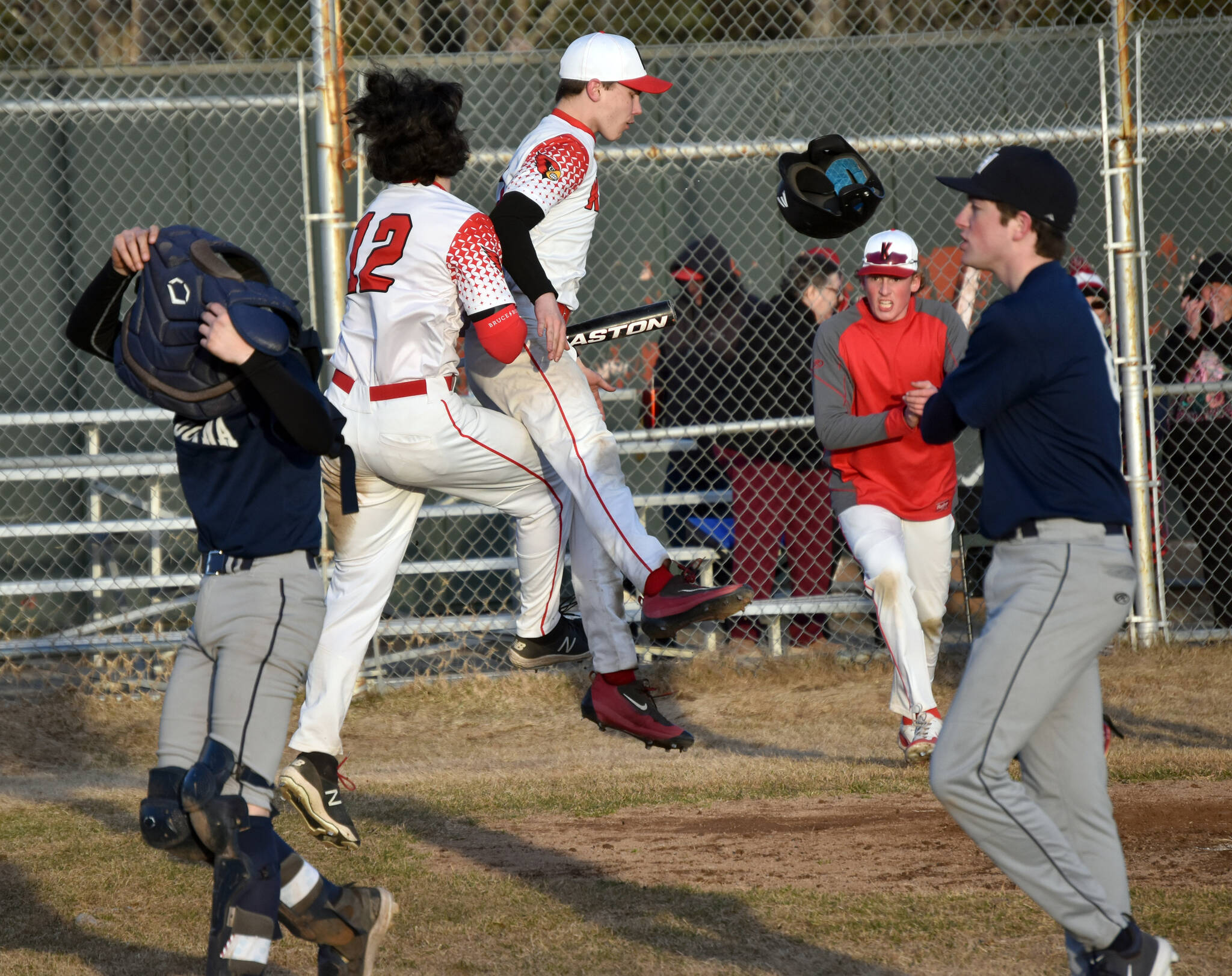 Kenai Centrals Zane Pellegrom (12) celebrates with Jackson Marion after Pellegrom scored the winning run against Soldotna on Monday, April 29, 2024, at the Kenai Little League fields in Kenai, Alaska. (Photo by Jeff Helminiak/Peninsula Clarion)
