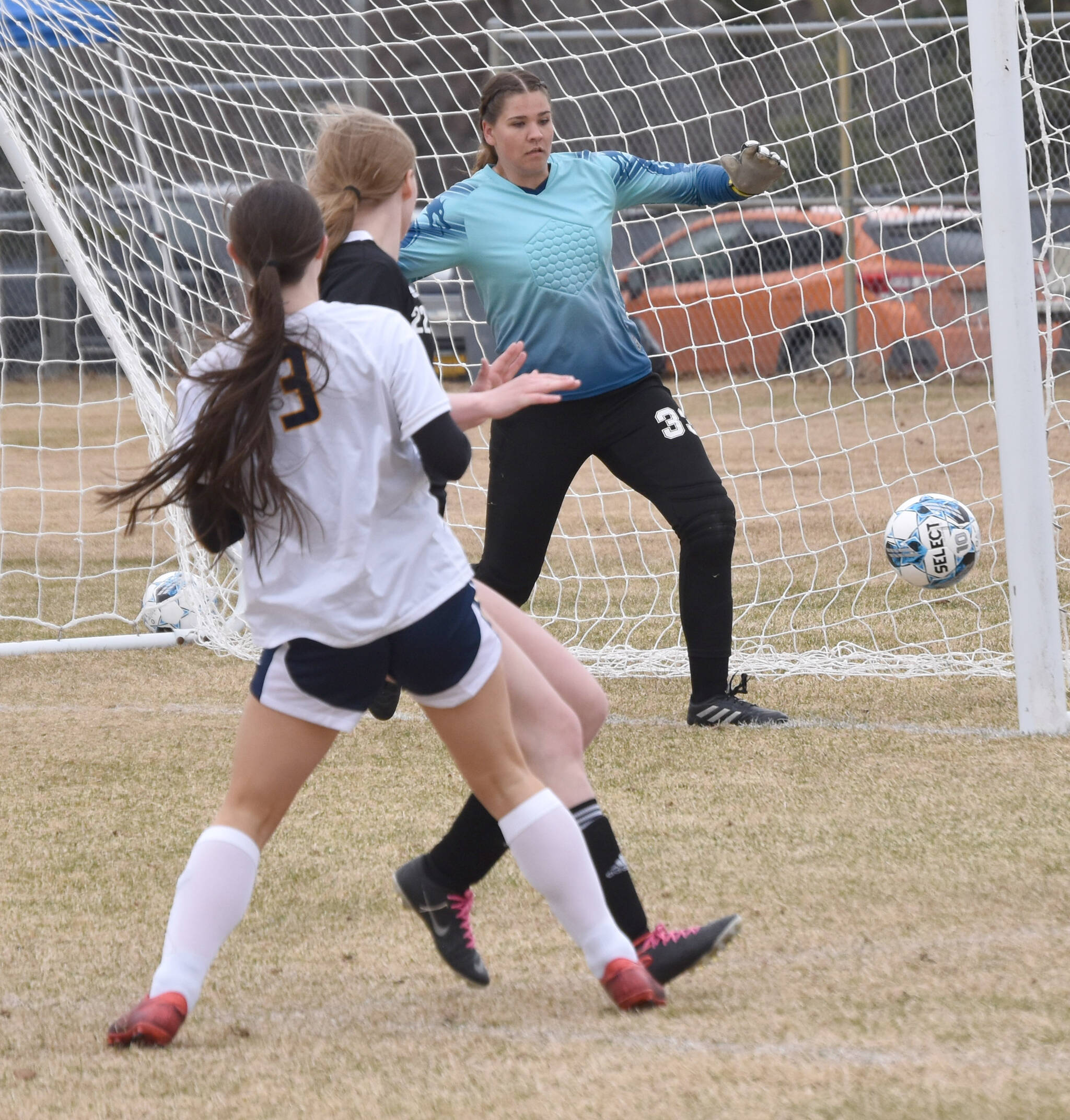Homers Addi Grimes hits the post in front of Nikiski goalie Emma Weeks on Saturday, May 4, 2024, at Nikiski Middle-High School in Nikiski, Alaska. (Photo by Jeff Helminiak/Peninsula Clarion)