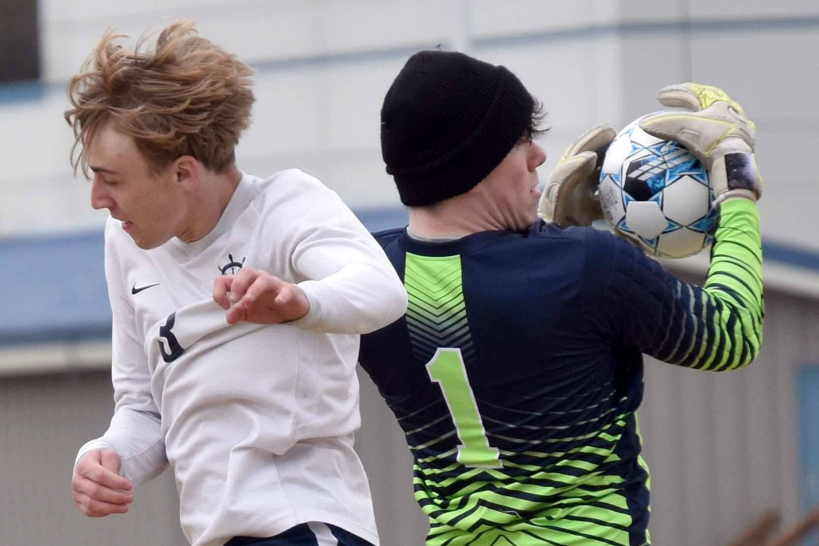 Nikiski goalie Kevin Love snatches the ball before Homer's Kaiden Bogie can head it Saturday, May 4, 2024, at Nikiski Middle-High School in Nikiski, Alaska. (Photo by Jeff Helminiak/Peninsula Clarion)