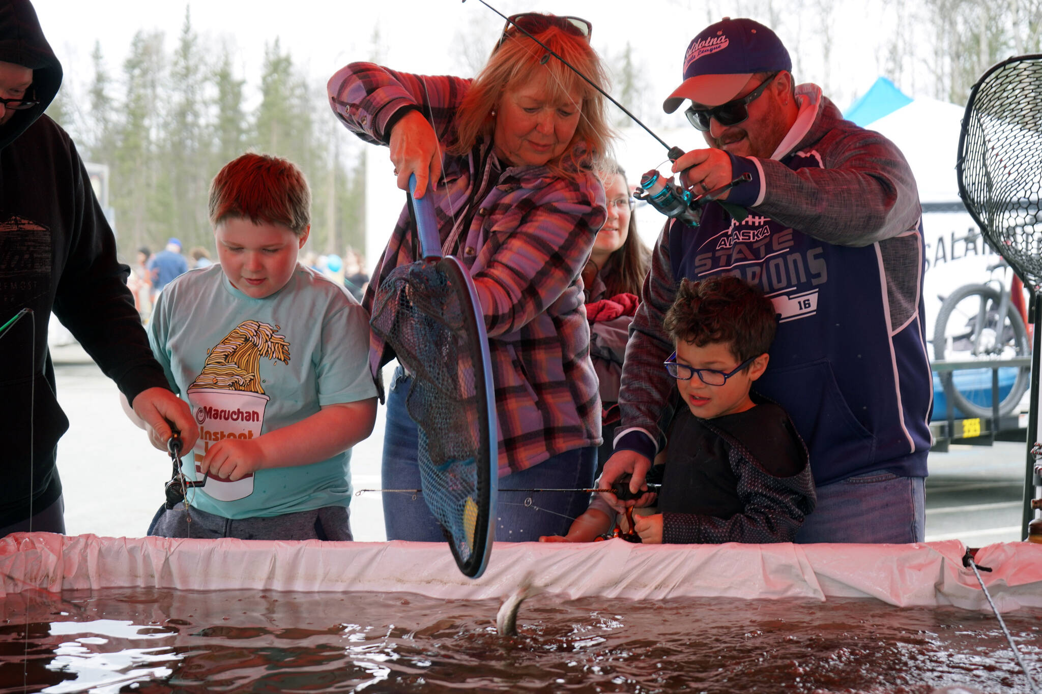 A rainbow trout is lifted into a net during the Sport, Rec and Trade Show at the Soldotna Regional Sports Complex in Soldotna, Alaska, on Saturday, May 4, 2024. (Jake Dye/Peninsula Clarion)