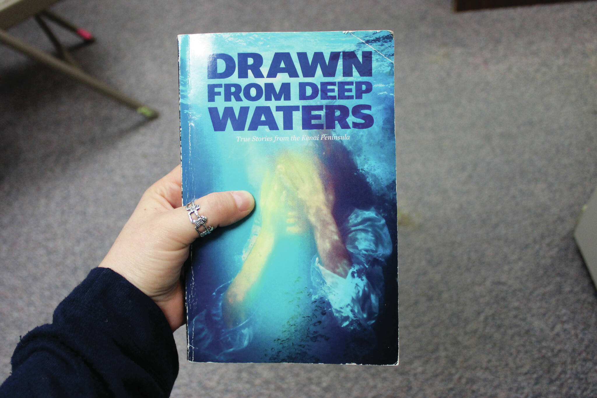 Ashlyn O’Hara/Peninsula Clarion
A copy of “Drawn from Deep Waters: True Stories from the Kenai Peninsula,” is held on Thursday in Kenai.