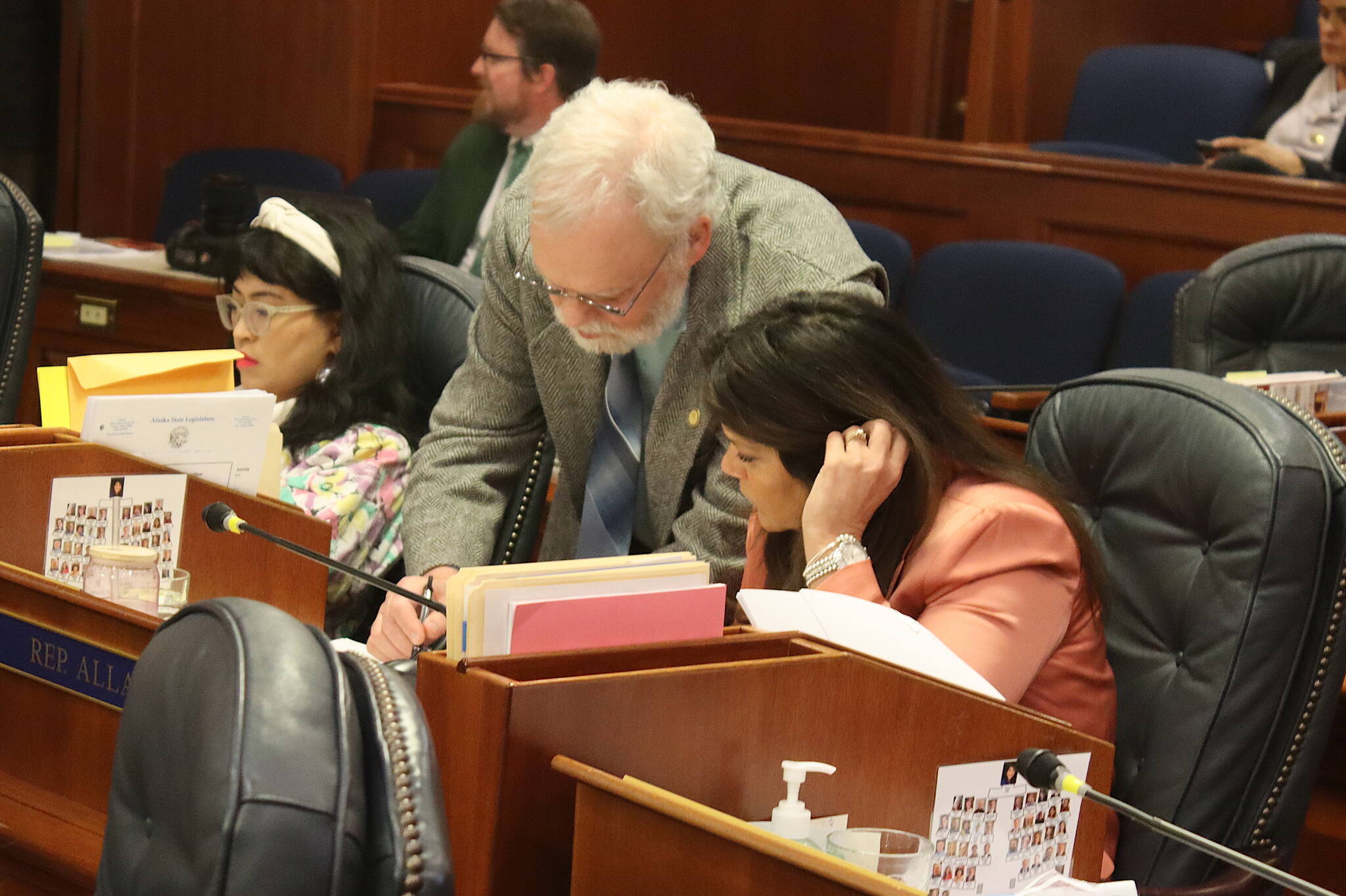 Rep. Jamie Allard, R-Eagle River, and Rep. Mike Prax, R-North Pole, discuss a proposed amendment to a bill sponsored by Allard restricting transgender students’ participation in school sports during a House floor session on Thursday, May 9, 2024. (Mark Sabbatini / Juneau Empire)