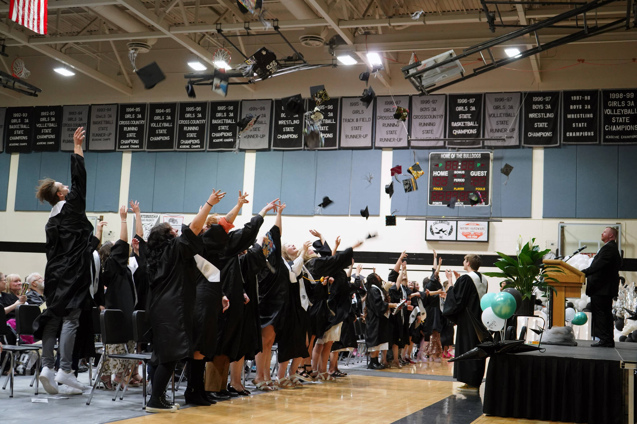 Nikiski Middle/High School graduates throw their caps into the air at the conclusion of a graduation ceremony in the school’s gym in Nikiski, Alaska, on Wednesday, May 15, 2024. (Jake Dye/Peninsula Clarion)