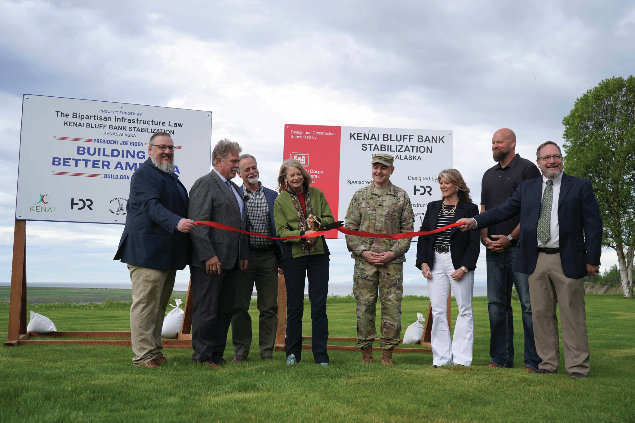 Jake Dye/Peninsula Clarion
City of Kenai Public Works Director Scott Curtain; City of Kenai Mayor Brian Gabriel; Kenai Peninsula Borough Mayor Peter Micciche; Sen. Lisa Murkowski; Col. Jeffrey Palazzini; Elaina Spraker; Adam Trombley; and Kenai City Manager Terry Eubank cut the ribbon to celebrate the start of work on the Kenai River Bluff Stabilization Project on the bluff above the Kenai River in Kenai on Monday.