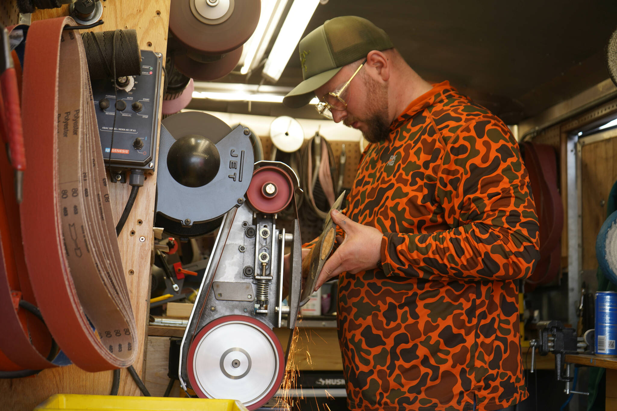 Sparks glitter away as Grey Wilson, of Wilson’s Proper Edge, sharpens an ax at Soldotna Creek Park in Soldotna, Alaska, on Wednesday, June 19, 2024. (Jake Dye/Peninsula Clarion)