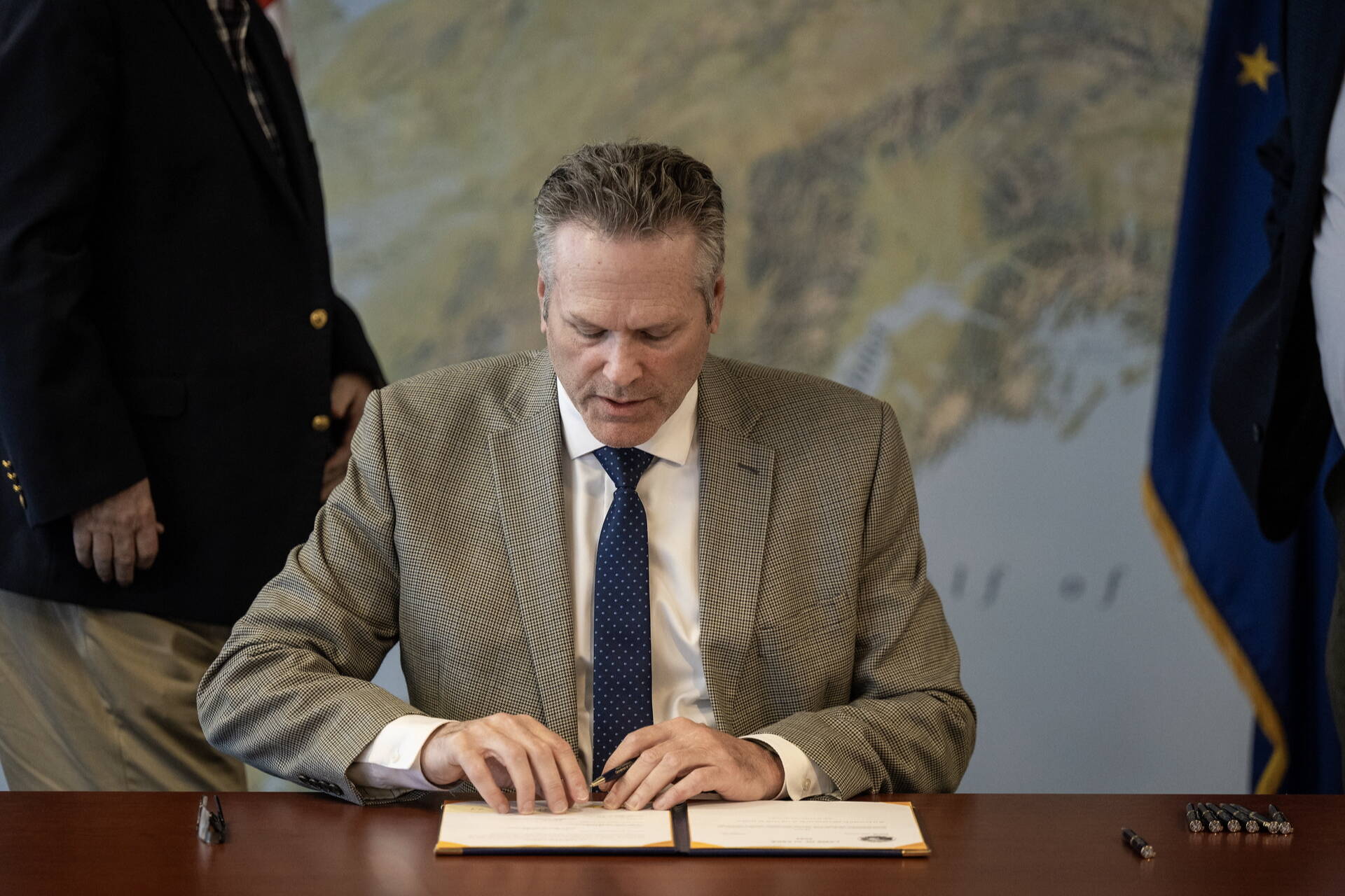 Gov. Mike Dunleavy signs bills for the state’s 2025 fiscal year budget during a private ceremony in Anchorage on Thursday, June 25, 2024. (Official photo from The Office of the Governor)