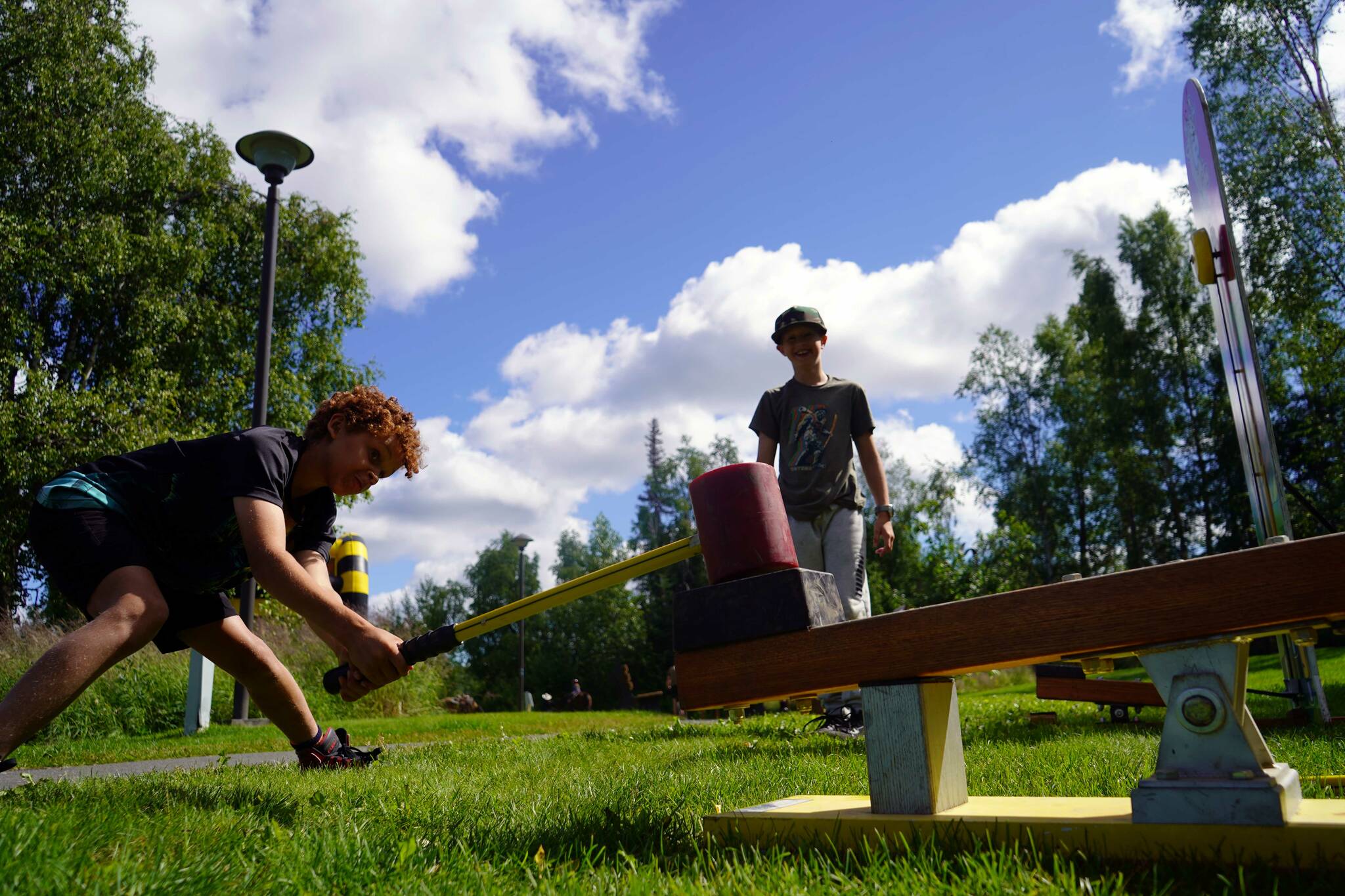 Children test their strength at a high striker during the Progress Days Block Party at Parker Park in Soldotna, Alaska, on Saturday, July 27, 2024. (Jake Dye/Peninsula Clarion)