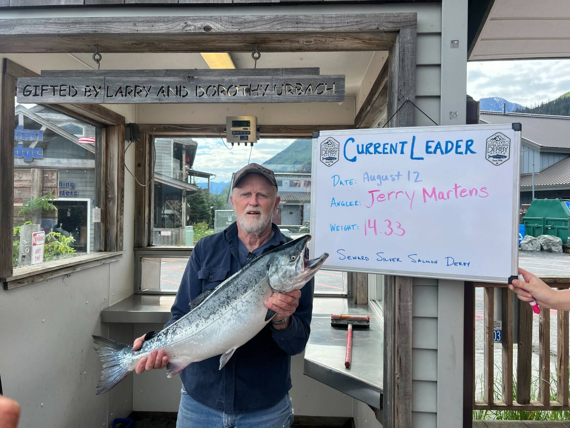 Jerry Martens holds up a 14.33 pound silver salmon on Monday, Aug. 12, 2024, in Seward, Alaska. On Monday, that silver was the largest fish caught in the 69th Annual Seward Silver Salmon Derby and also outweighs last year’s winning catch. (Photo provided by Seward Chamber of Commerce)