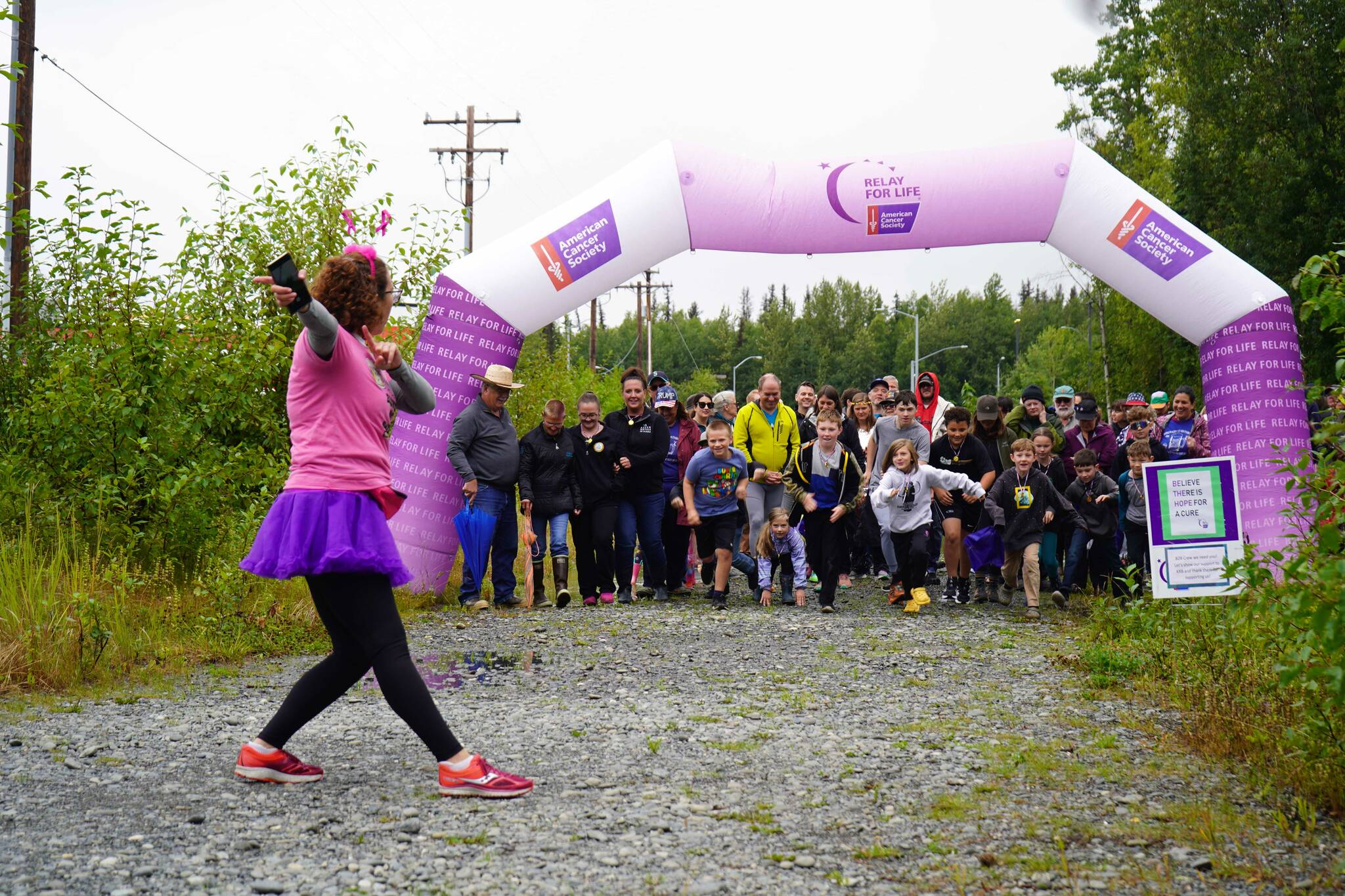 Organizer Alana Martin looses the racers for the Brewery to Bathroom .5K “The Race for the Rest of Us” at Kenai River Brewing in Soldotna, Alaska, on Saturday, Aug. 11, 2024. (Jake Dye/Peninsula Clarion)