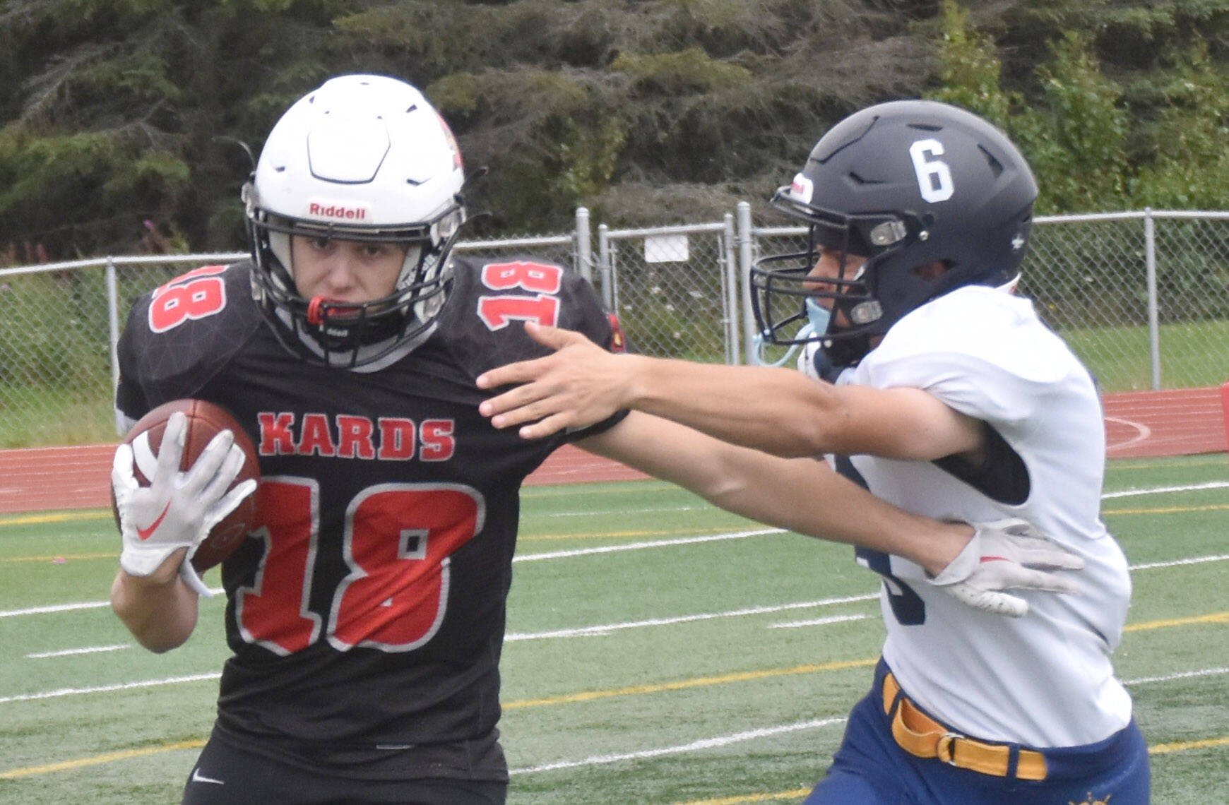 Kenai Centrals Aasen Campanella rushes the ball against Homers Austin Briscoe on Saturday, Aug. 17, 2024, at Ed Hollier Field at Kenai Central High School in Kenai, Alaska. (Photo by Jeff Helminiak/Peninsula Clarion)