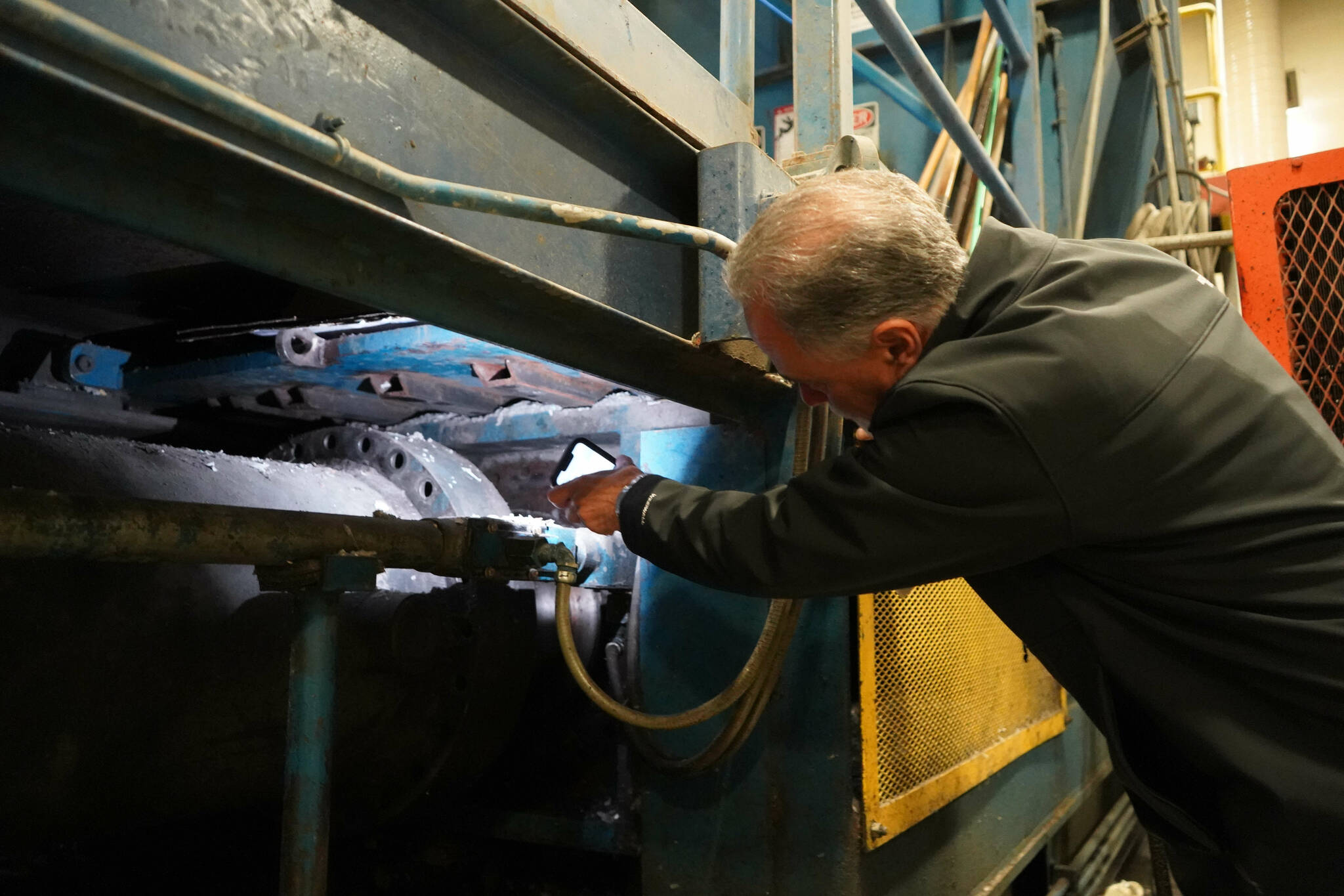 Kenai Peninsula Borough Mayor Peter Micciche points to where the baler ram severed from the machine at the Central Peninsula Landfill in Soldotna, Alaska, on Thursday, Jan. 16, 2025. (Jake Dye/Peninsula Clarion)