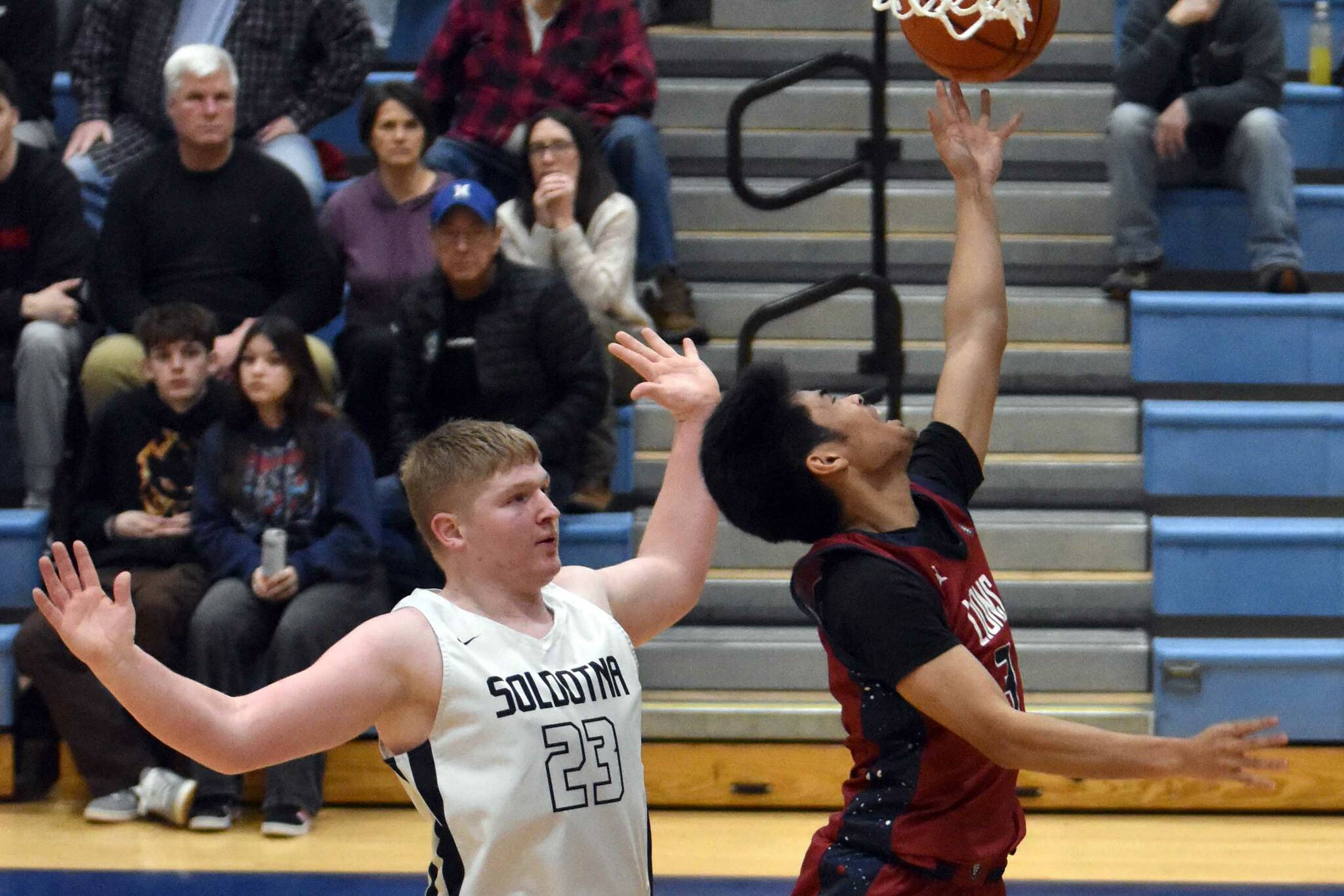 Jaidhen Oyao of Mountain City Christian Academy drives against Theo Huff of Soldotna on Friday, Jan. 17, 2025, at Soldotna High School in Soldotna, Alaska. (Photo by Jeff Helminiak/Peninsula Clarion)