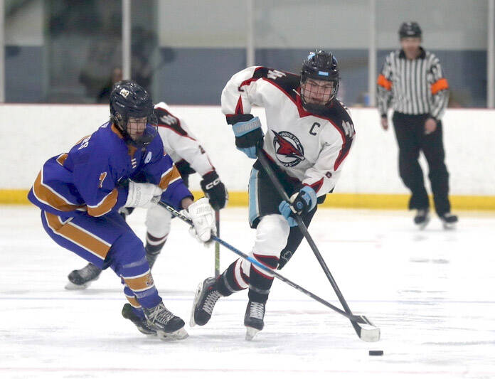 Homer’s Zane Barth tries to poke the puck away from Houston’s Daniel Matveev during an 8-2 loss to the Hawks Friday, Jan. 17, 2024, at the Menard Arena in Wasilla, Alaska. (Bruce Eggleston/matsusports.net)