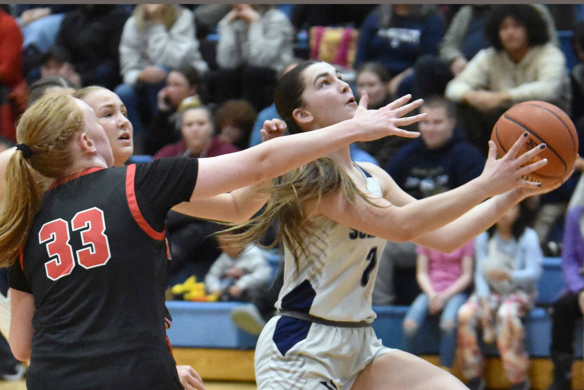 Soldotna's Anaulie Sedivy drives past Kenai Central's Ellsi Miller and Gracee Every on Friday, Jan. 24, 2025, at the Revolution Sport and Spine Therapy Al Howard Shootout at Soldotna High School in Soldotna, Alaska. (Photo by Jeff Helminiak/Peninsula Clarion)